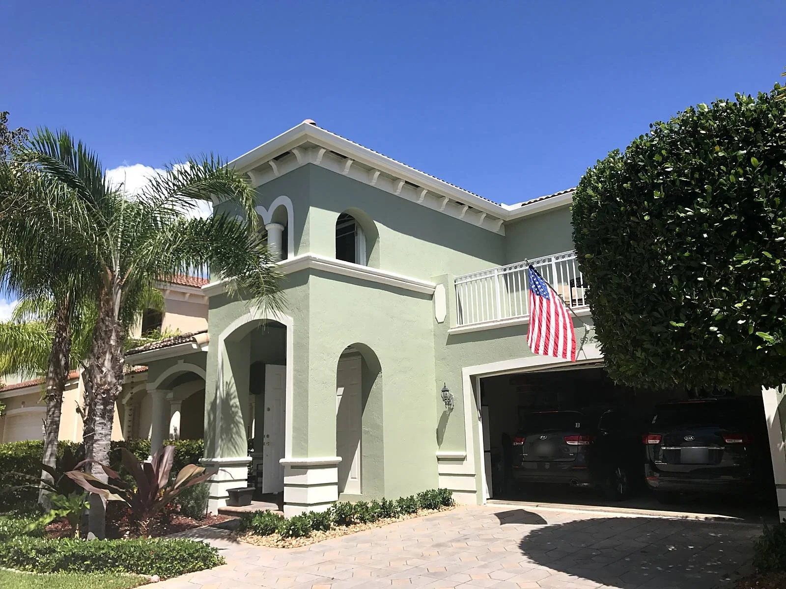 Seamless white aluminum gutter along the barrel tile roofline of a two-story Mediterranean home in Miami, FL