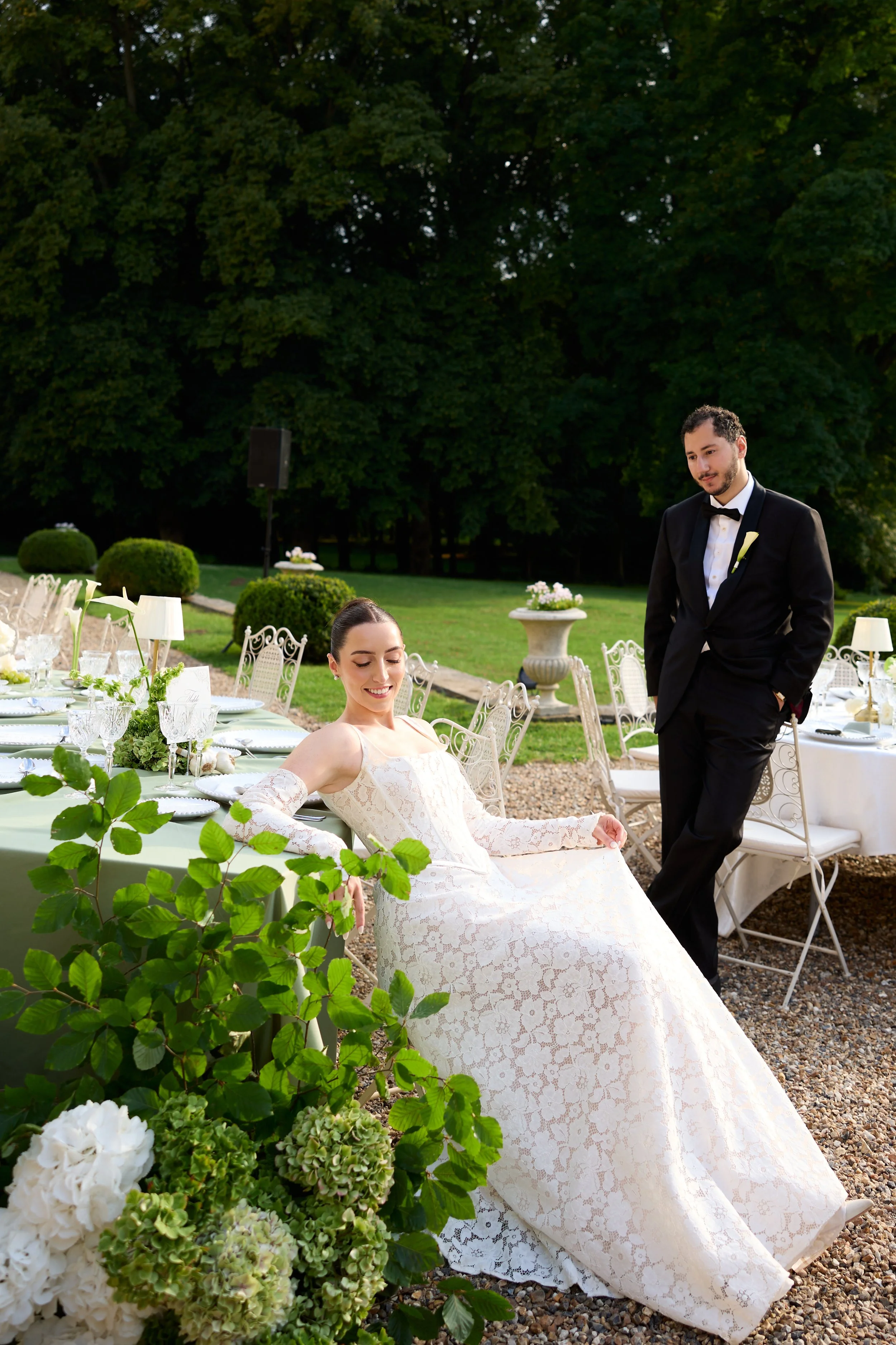 An overhead view of a formal outdoor dining event with multiple tables filled with guests eating and talking.