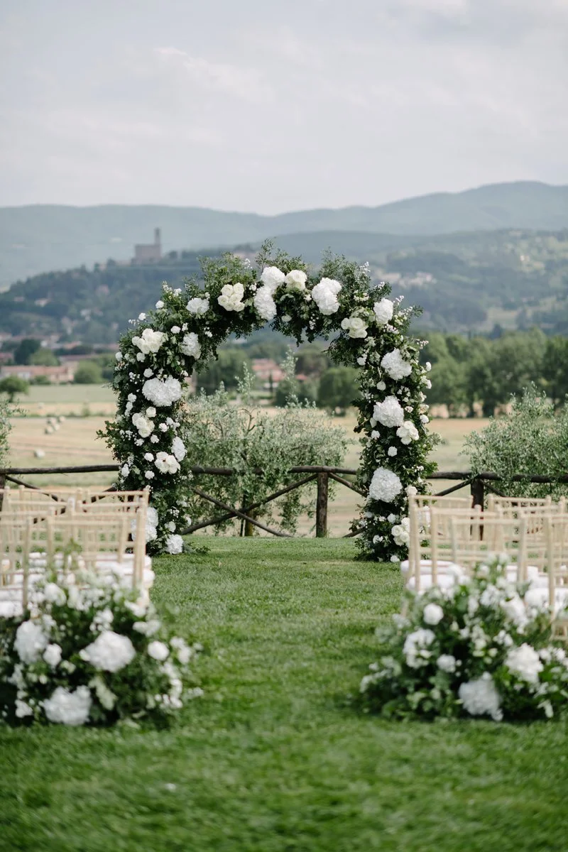 White floral arch for a ceremony in Tuscany, timeless and stylish wedding styling by FunkyBird, specialists in weddings in Italy.
