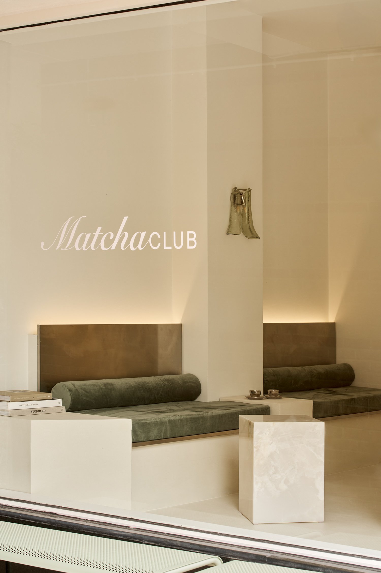 Onyx Matcha Club, London's new destination for matcha and modern rituals. Designed by OT Interiors. Owned by Leonie Hanne.
Minimalist store interior with built-in seating and decorative items, displaying the logo 'Matcha CLUB' on the wall.