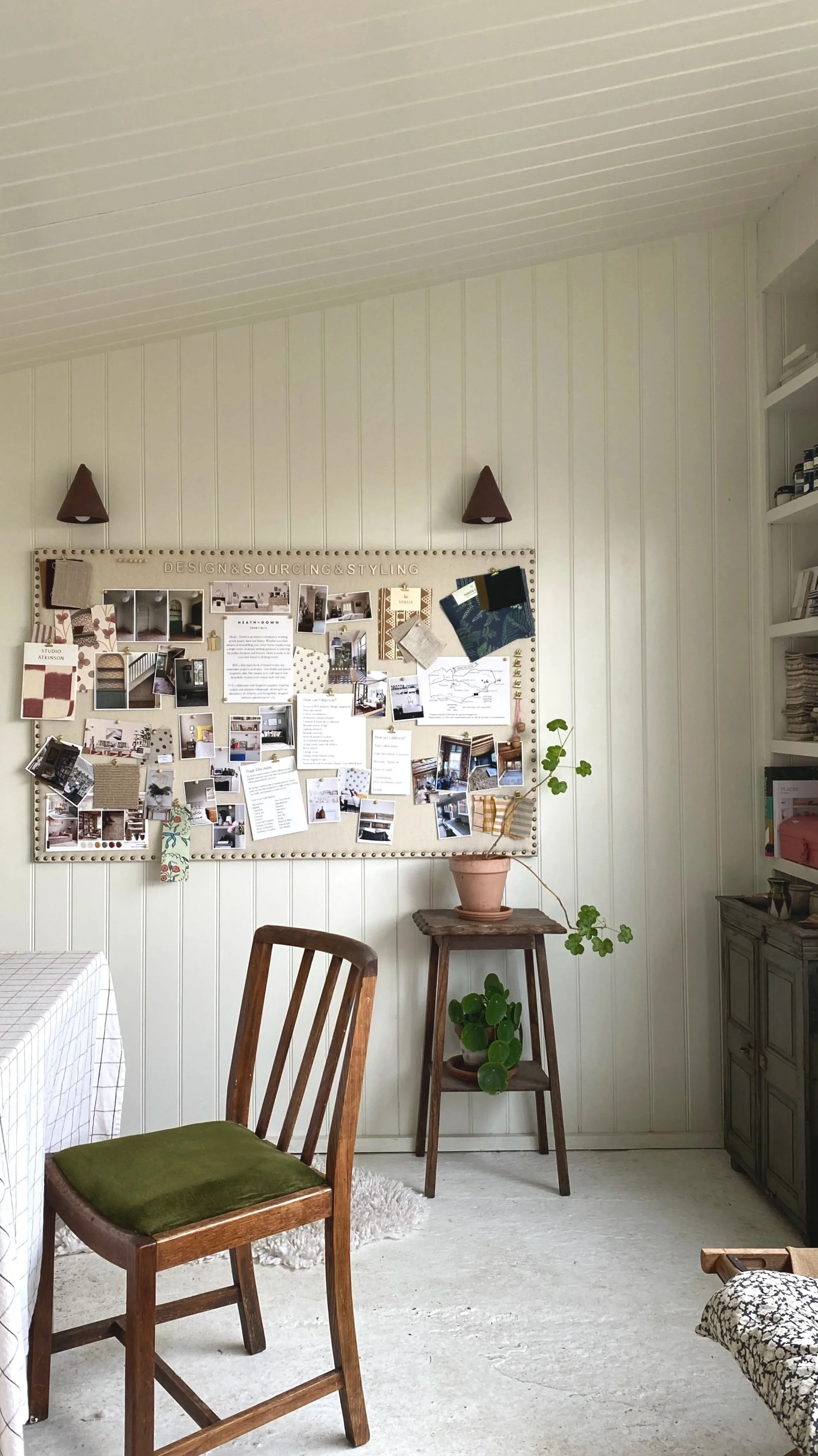 Interior design studio showing a desk and pinboard advertising services