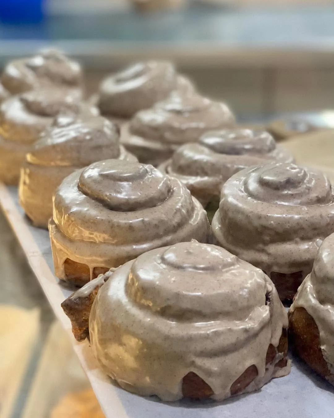 Everything makes your mouth water here! Brioche Cinnamon Buns with drippy glaze, stacks of chocolate croissants, and Fruit Danish.
