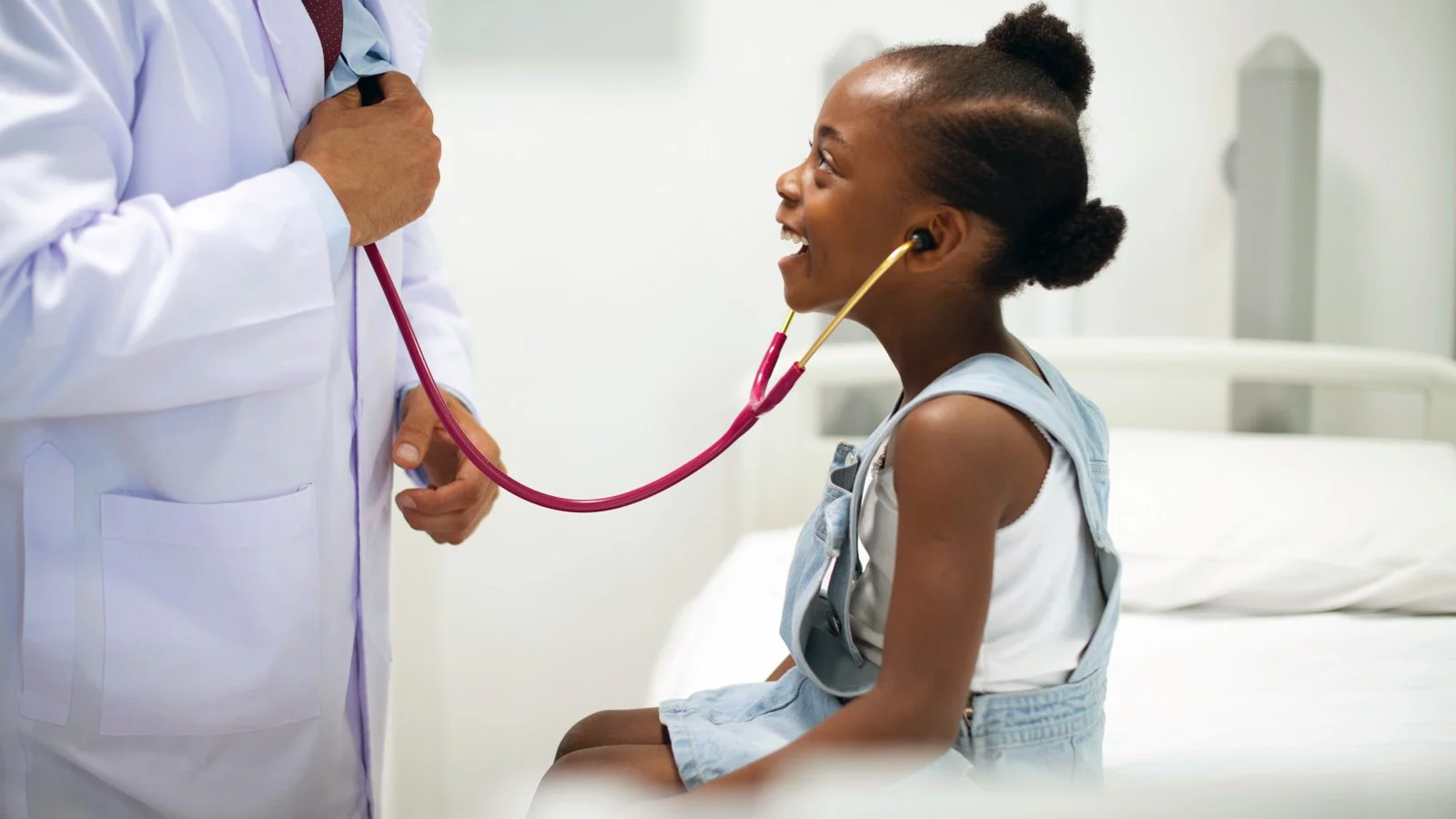 Child smiling looking up at doctor