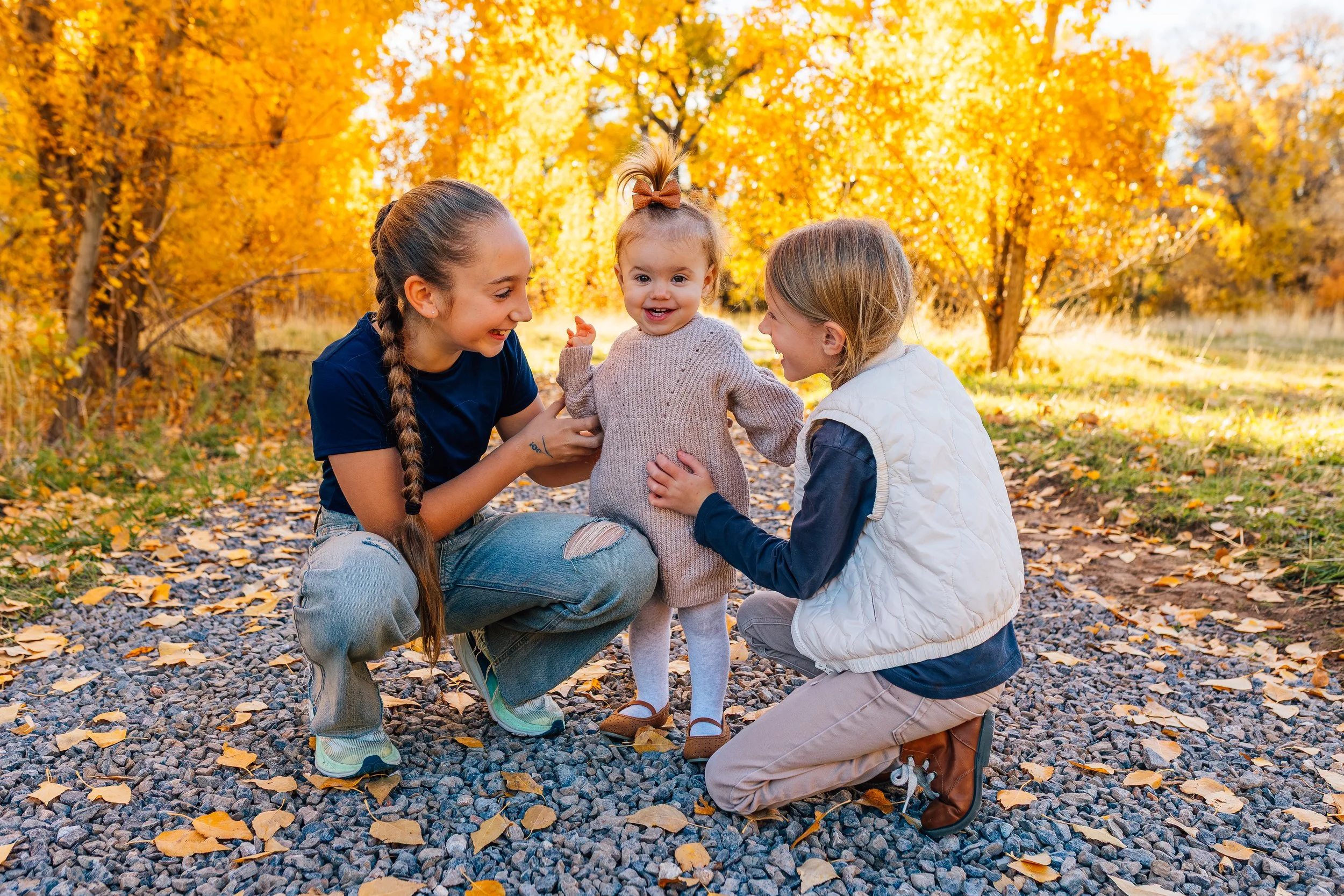 Candid documentary family photo of siblings interacting during a fall family session in Northern Utah, captured in natural light