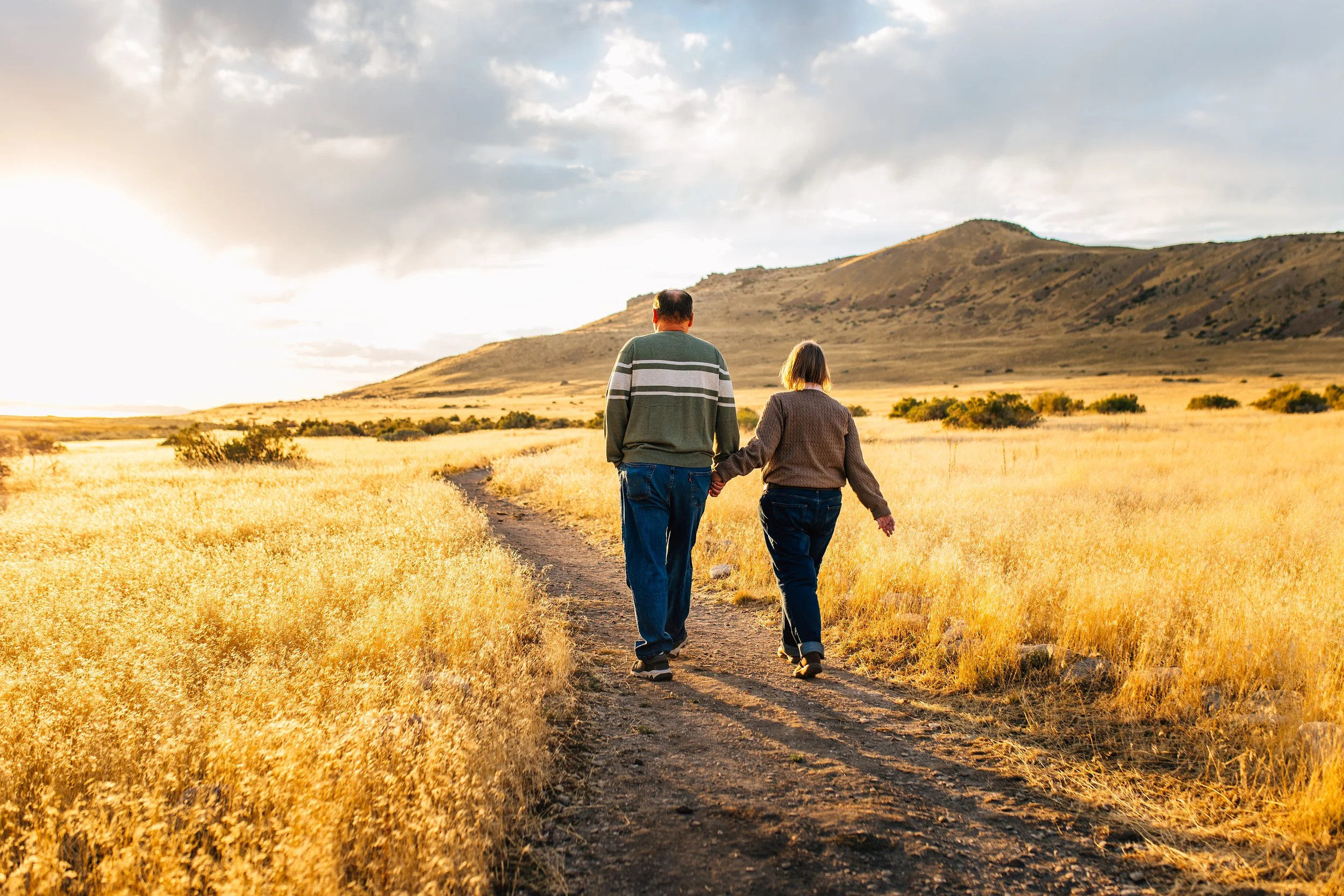 Family walking hand in hand along a trail during a winter family photography session at Antelope Island in Utah