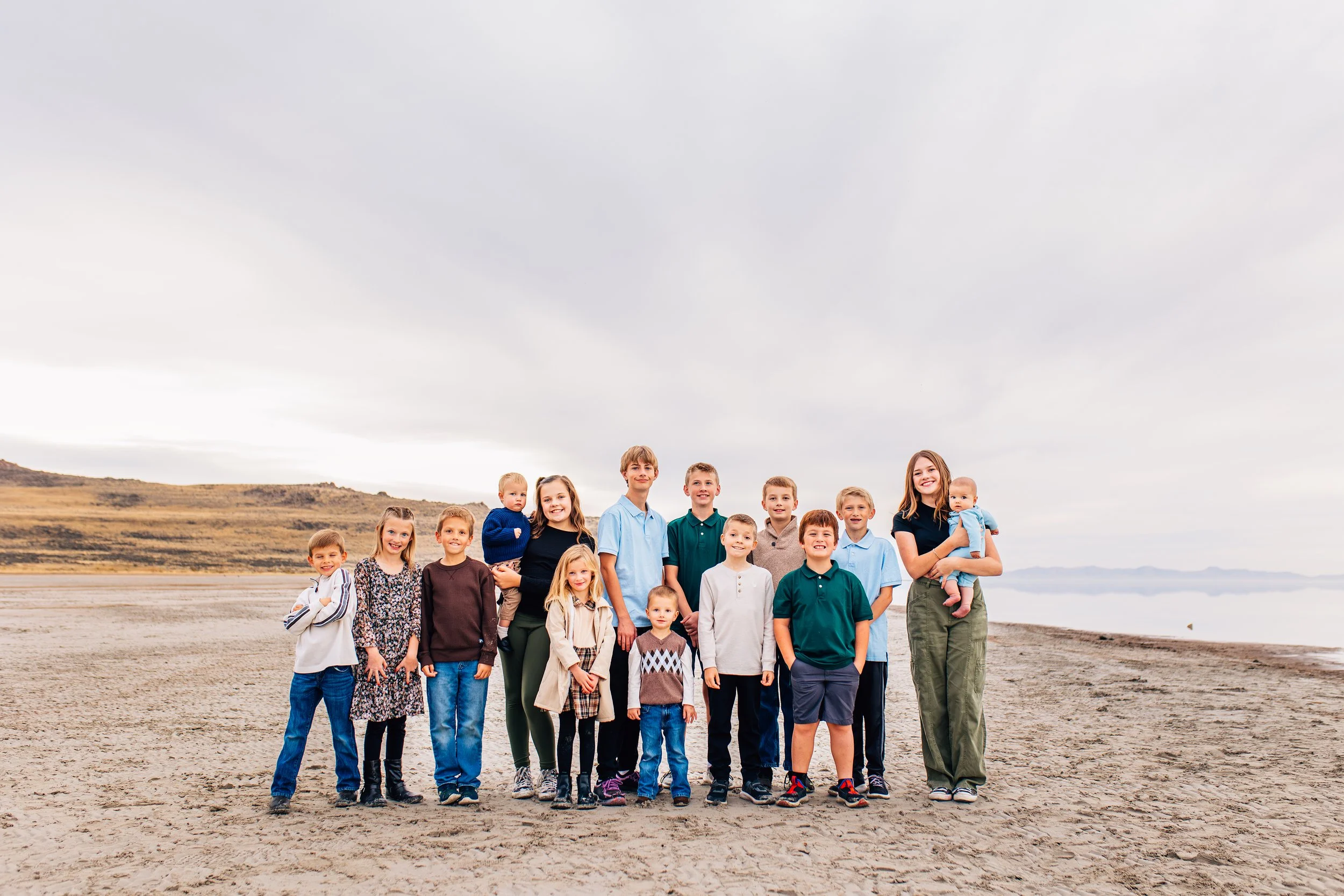 Extended family group standing together during a winter family photography session at Antelope Island in Utah