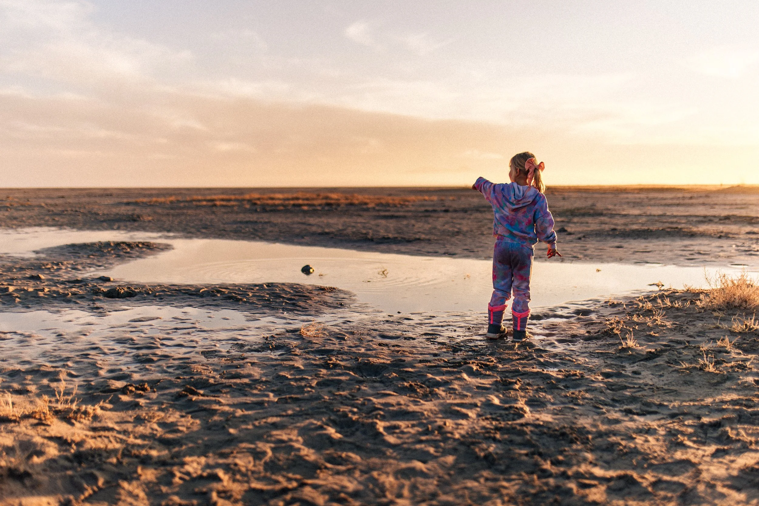 Child exploring the shoreline during a winter family photography session at Antelope Island in Utah