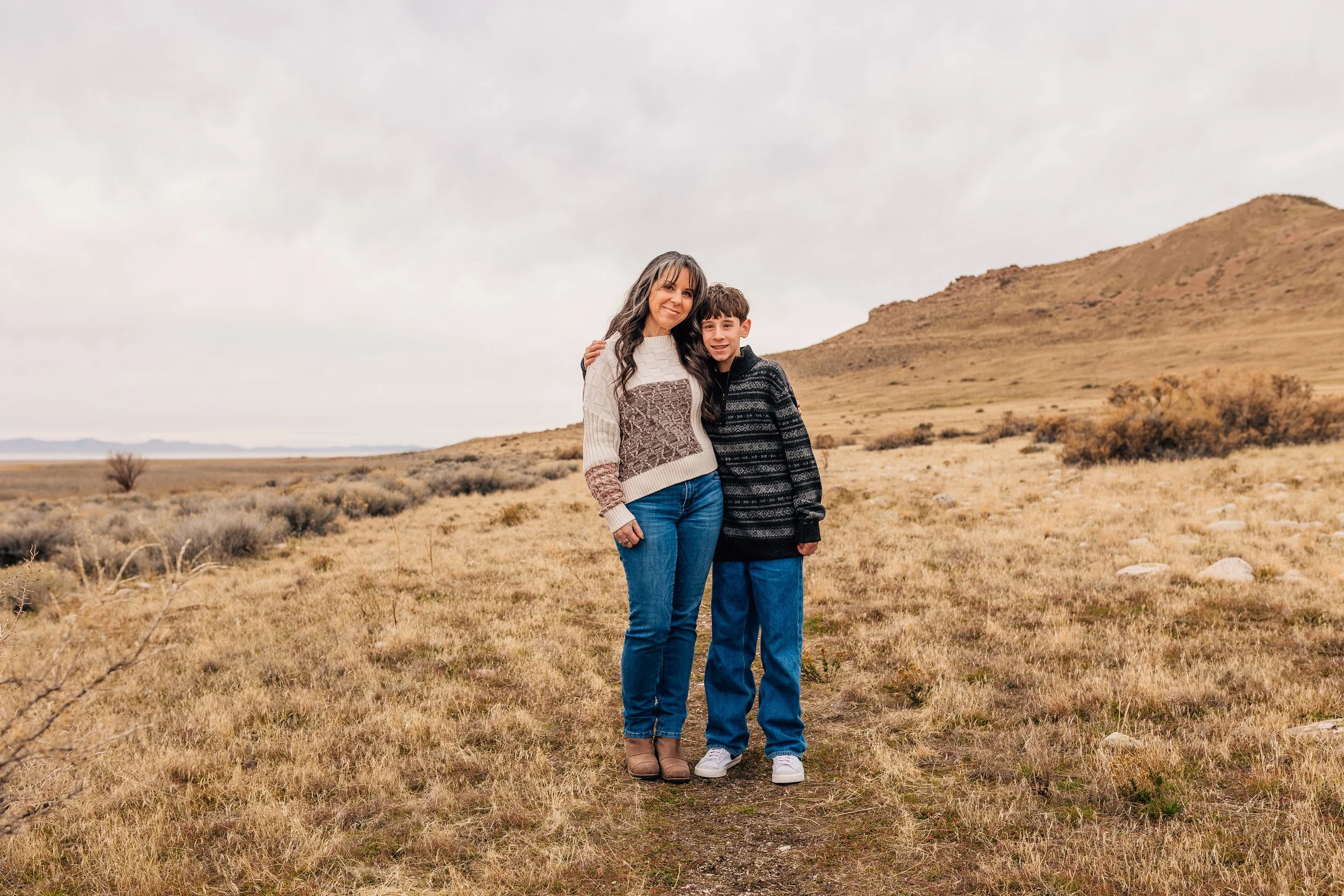 Mother and son standing together during a winter family photography session at Antelope Island in Utah