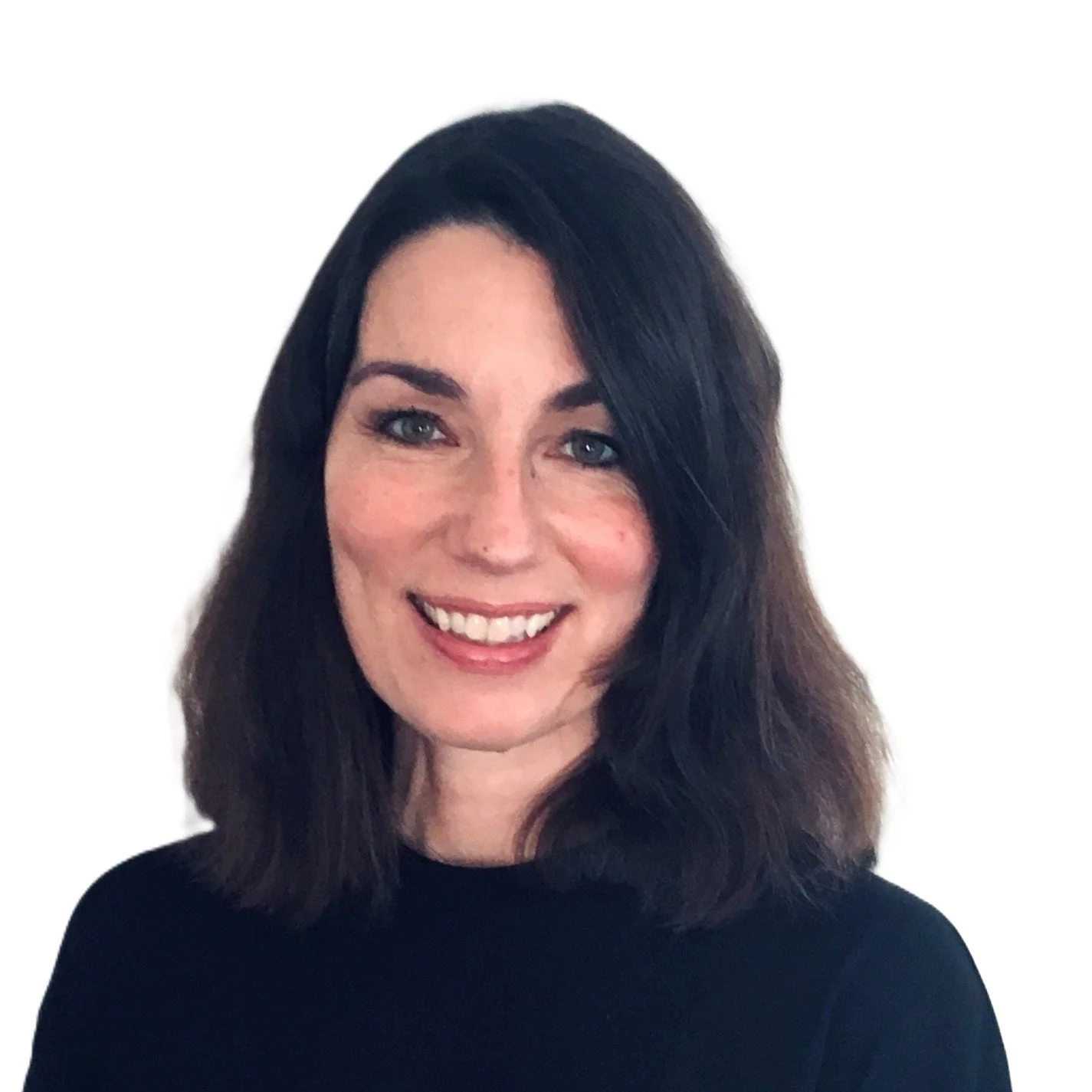 A woman with shoulder-length dark brown hair, blue eyes, and a bright smile, wearing a black top, posed against a plain white background.