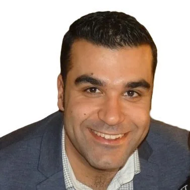 A smiling man with short dark hair, wearing a blazer and a collared shirt, against a white background.