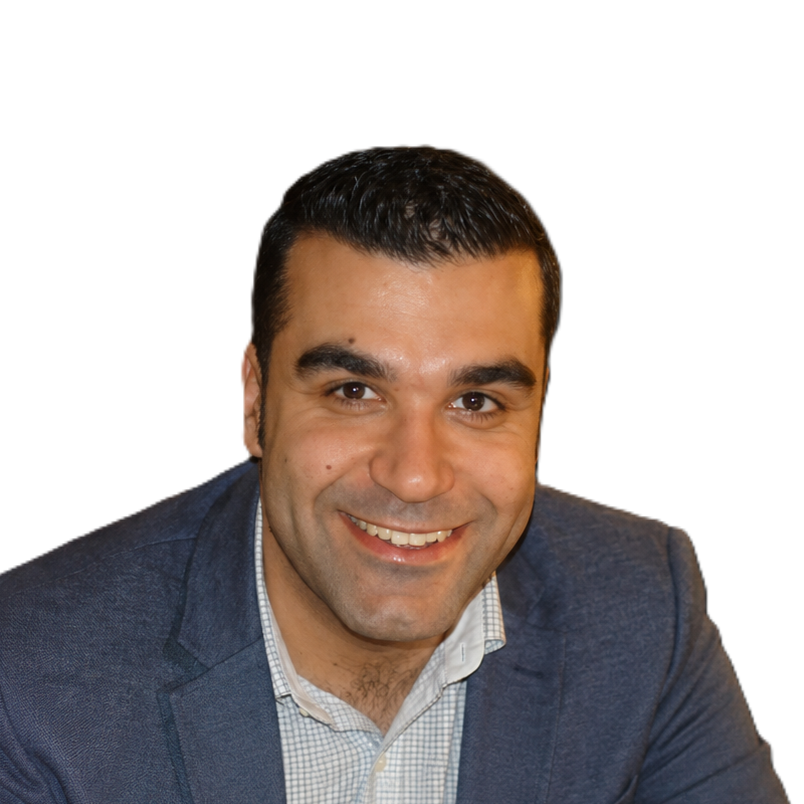 A smiling man with dark hair wearing a blue blazer and a checked shirt.