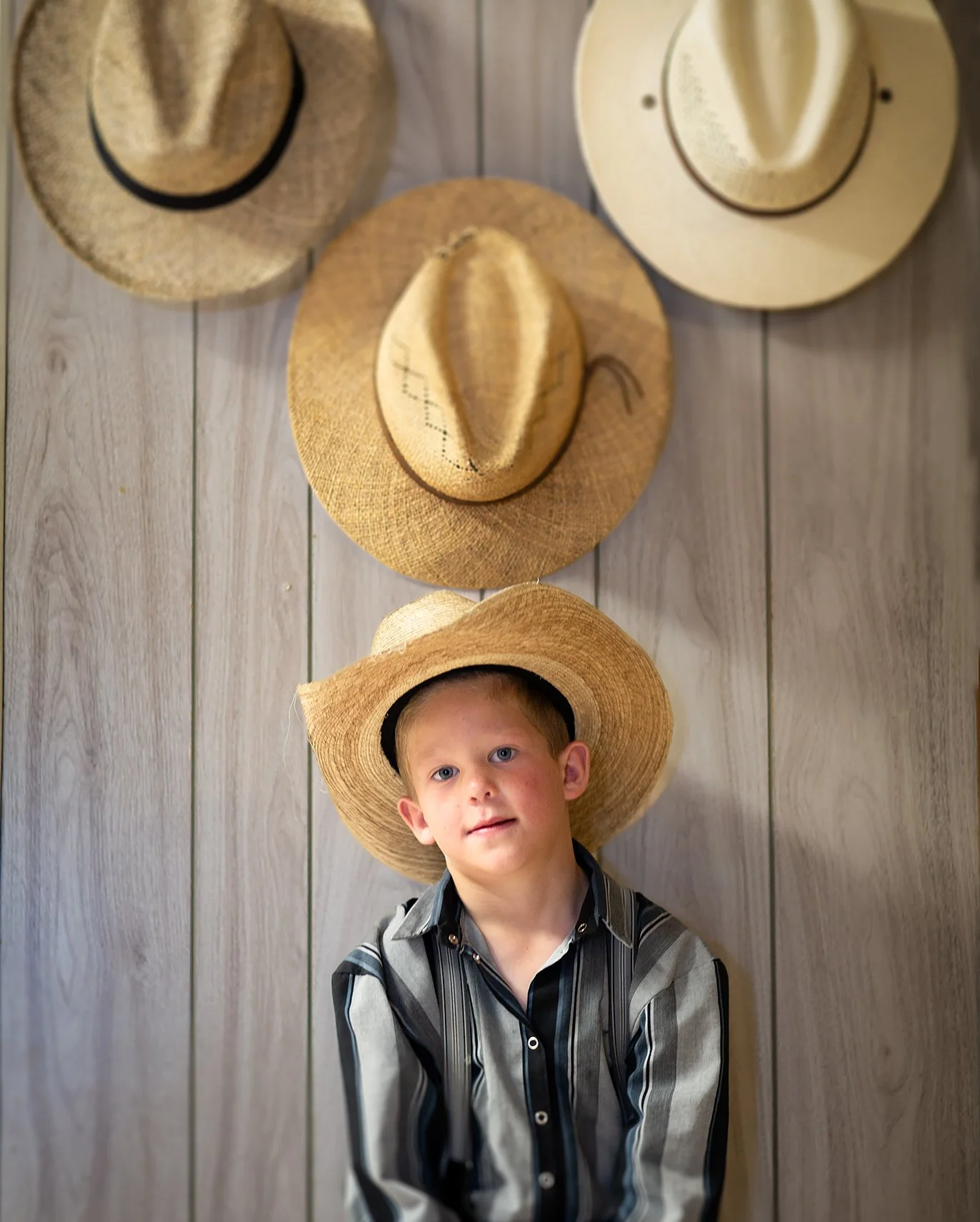 Hutterite boy with cowboy hats. Portrait by Dave White photographer. 