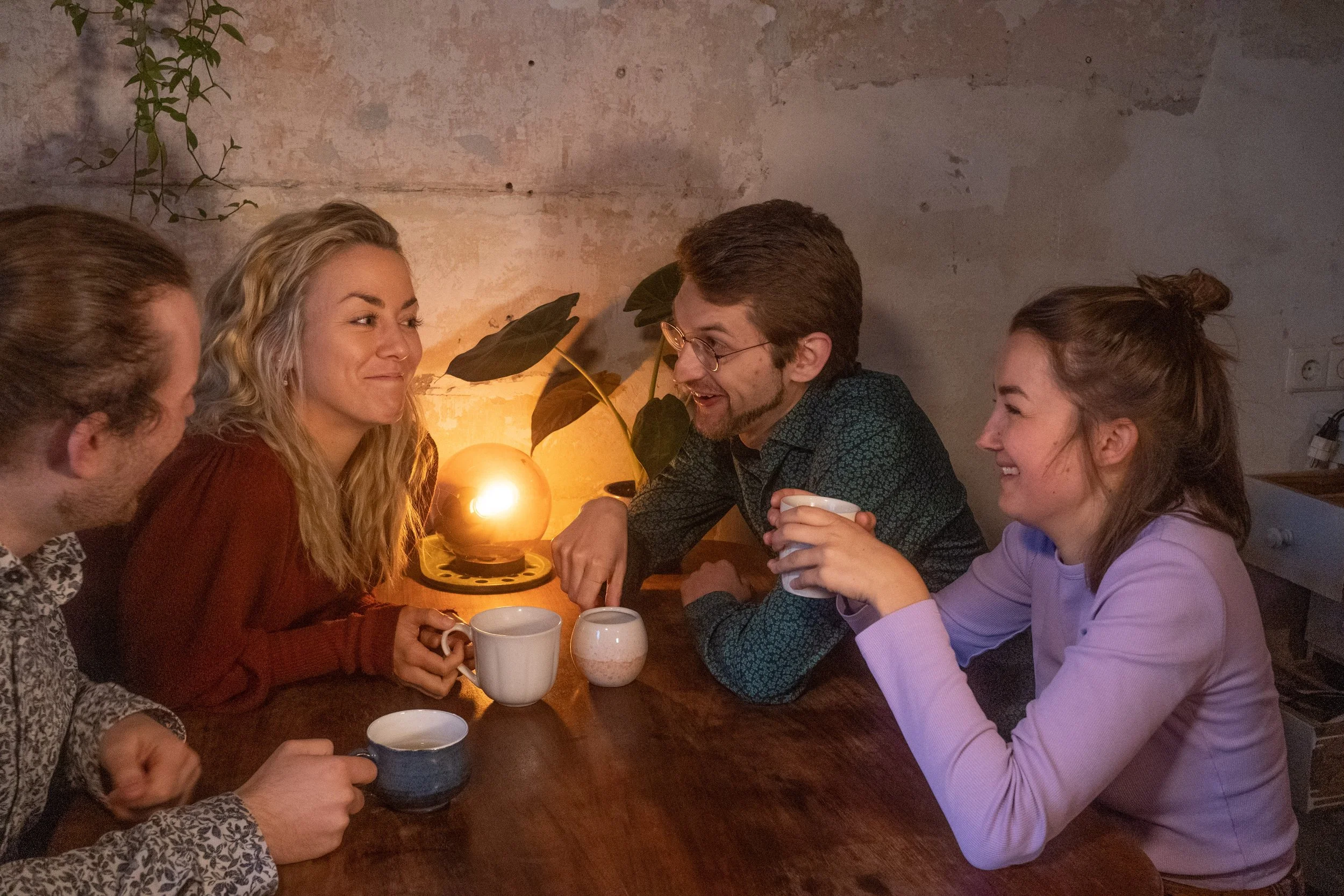 Jonathan, Fine, Max und Lilly sitzen in der Küche und lachen.