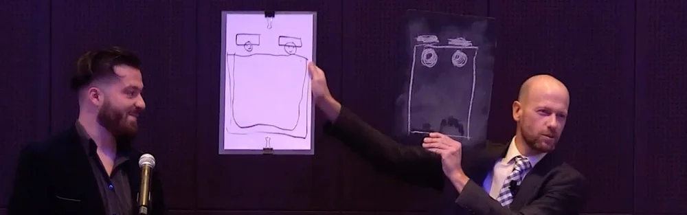 Mentalist Fred Berthelot revealing a drawing that matches a volunteer's on stage