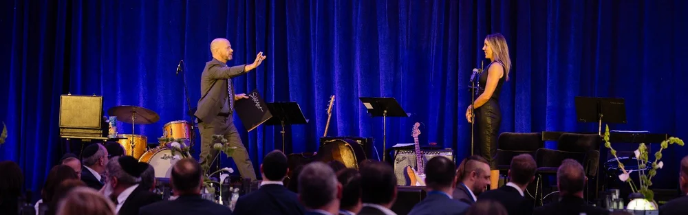 Mentalist Fred Berthelot on stage with a volunteer in front of a corporate audience
