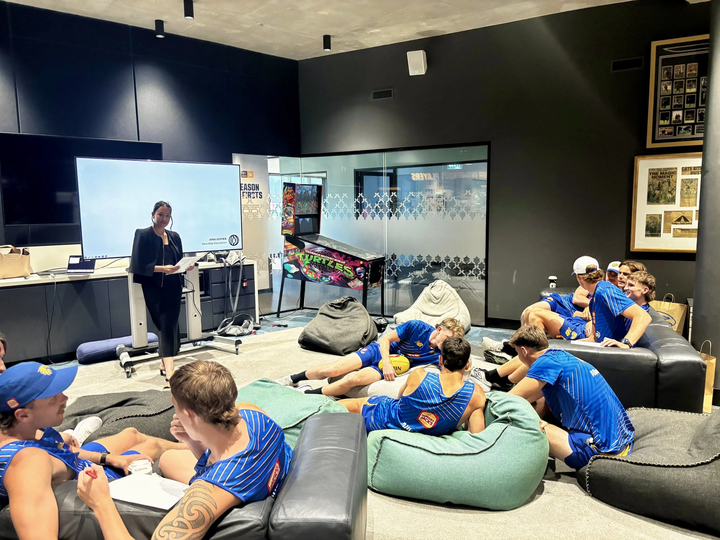 Jana standing in front of a group of athletes who are participating in a workshop