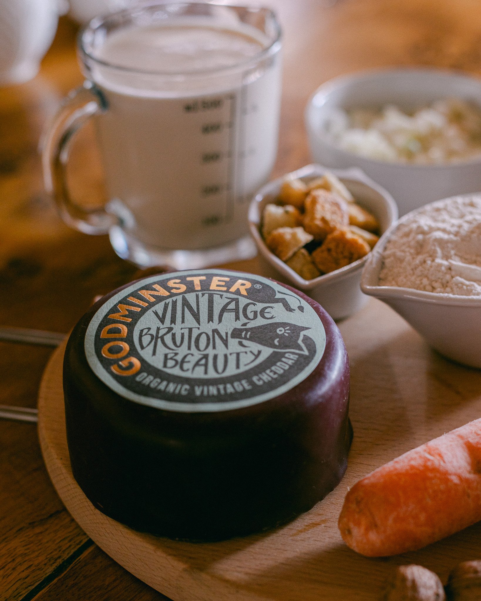 A block of Godminster Vintage Cheddar arranged with ingredients to make a delicious cheddar cheese soup