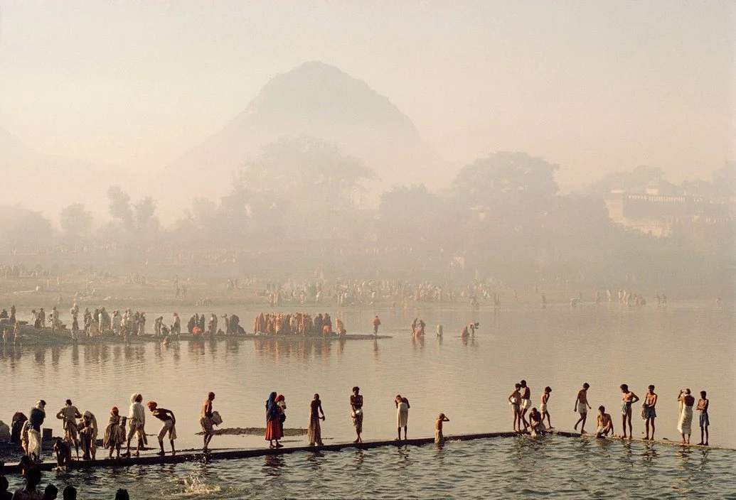 Paisagem na Índia com rapazes saltando para um rio, capturando a energia e liberdade do momento