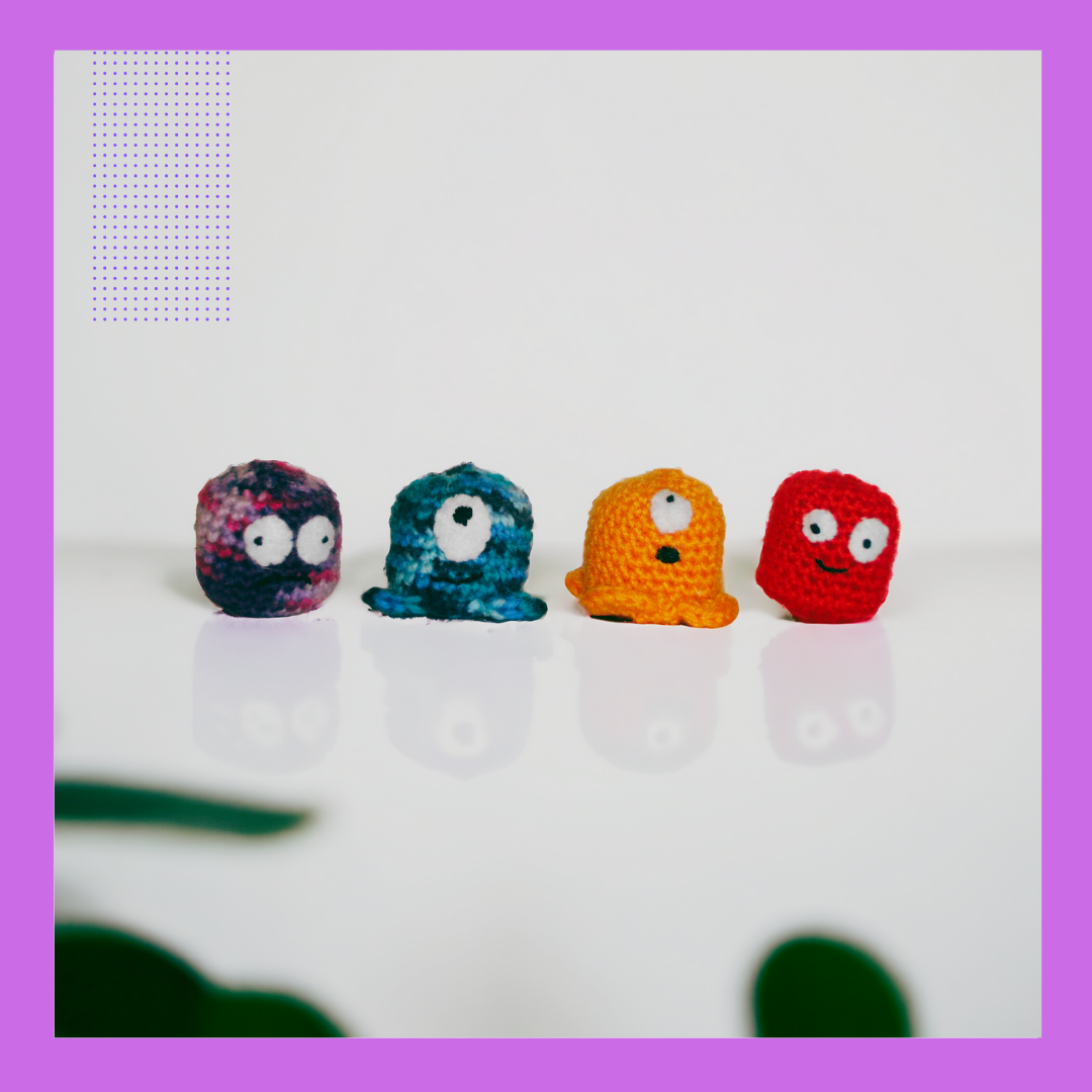 four marshmallow shaped crochet toys with funny embroidered faces