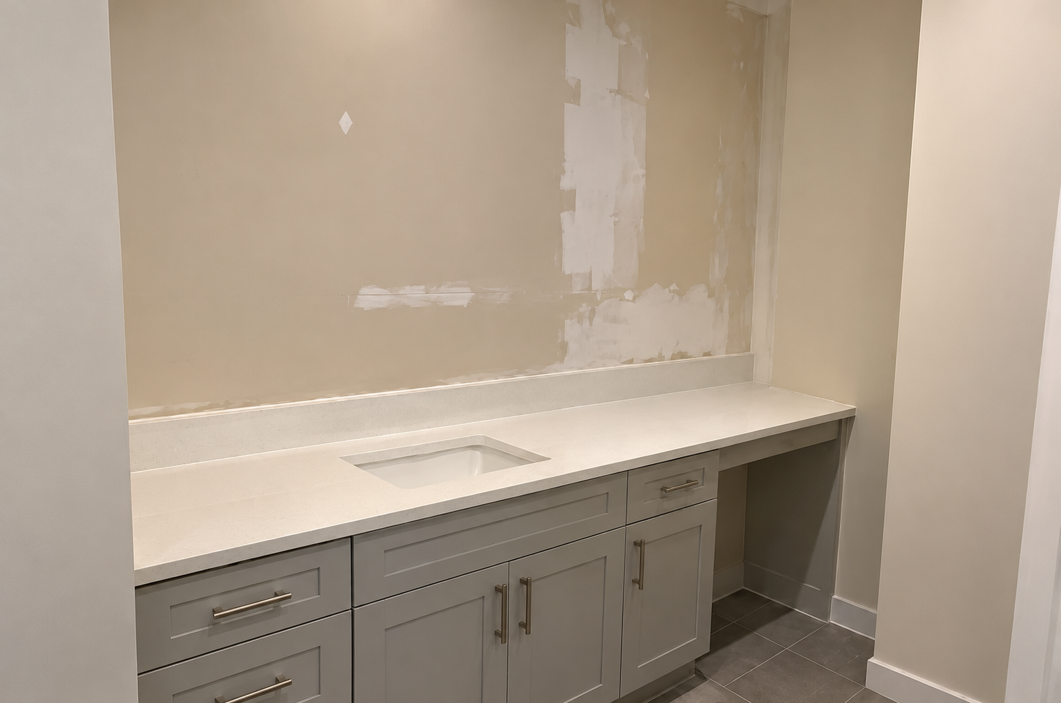 Bathroom vanity wall being prepared for tile installation above the countertop.