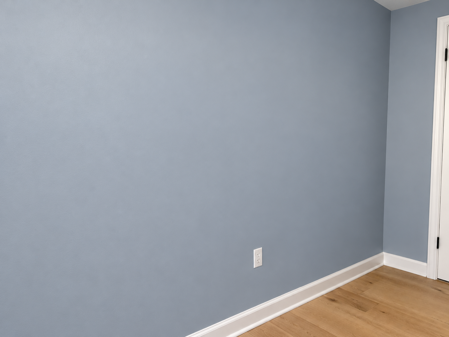 Finished drywall repair with smooth grey painted walls and white baseboards in Edmonton.