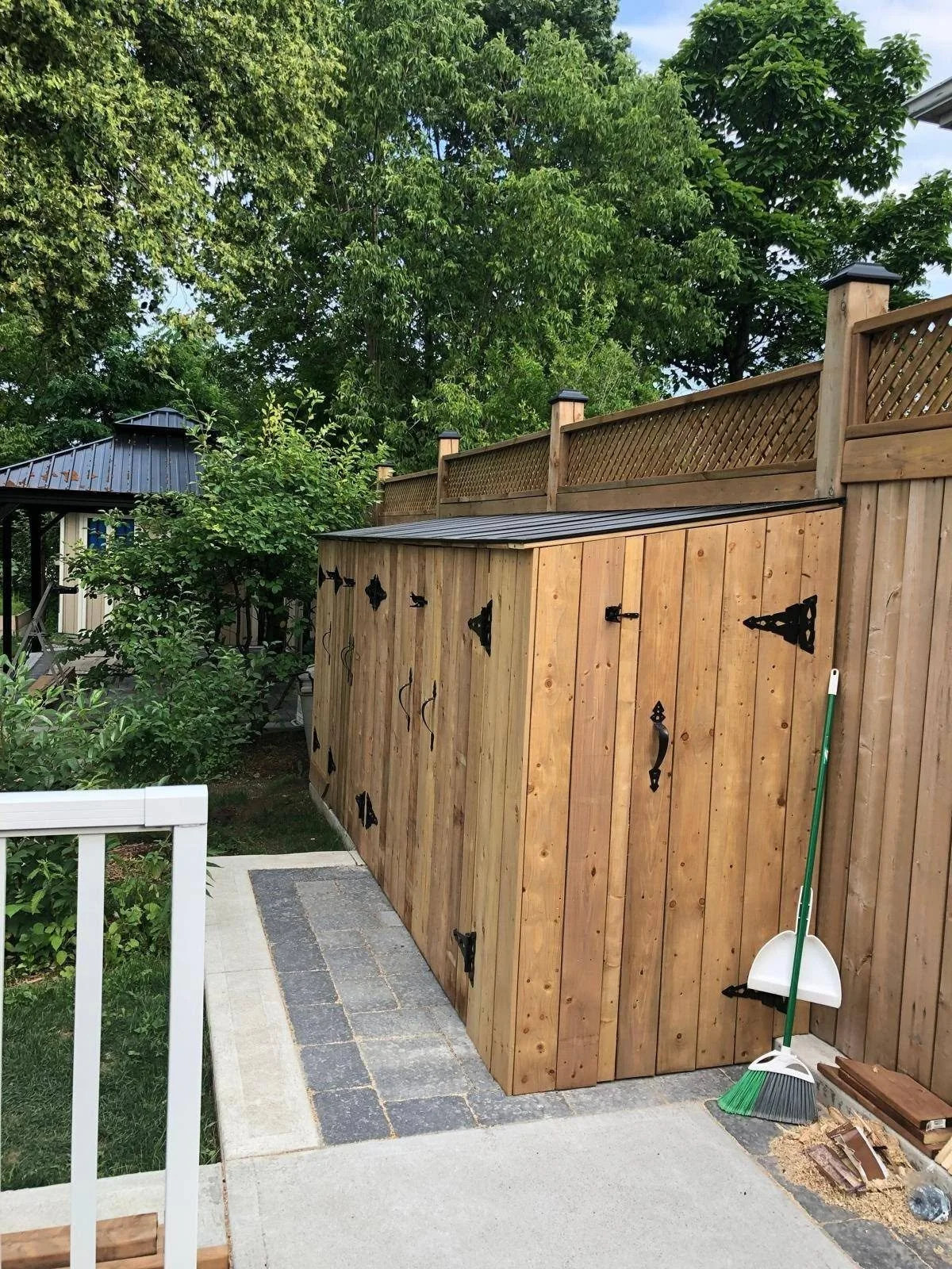 Wooden privacy fence with matching gate and a paved side-yard walkway beside a residential property.