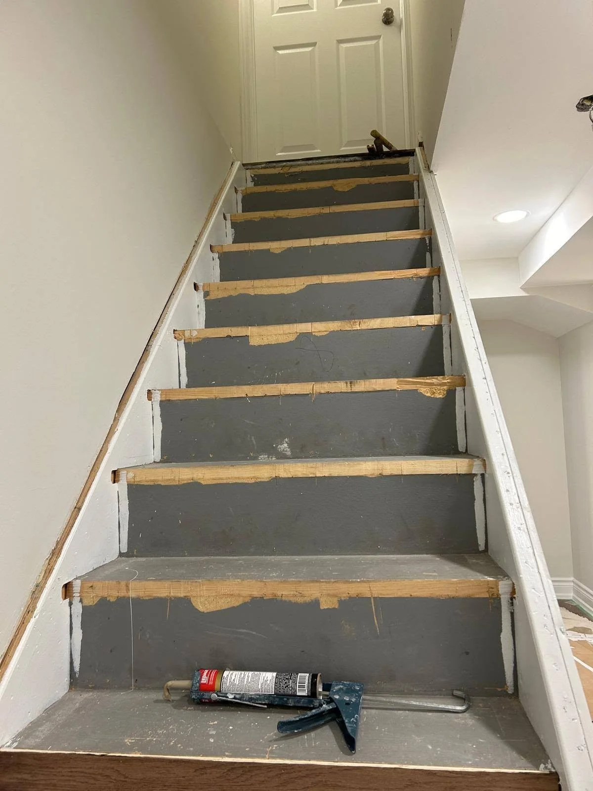 Interior staircase renovation in progress, with stair treads and risers being prepared for new finishing.