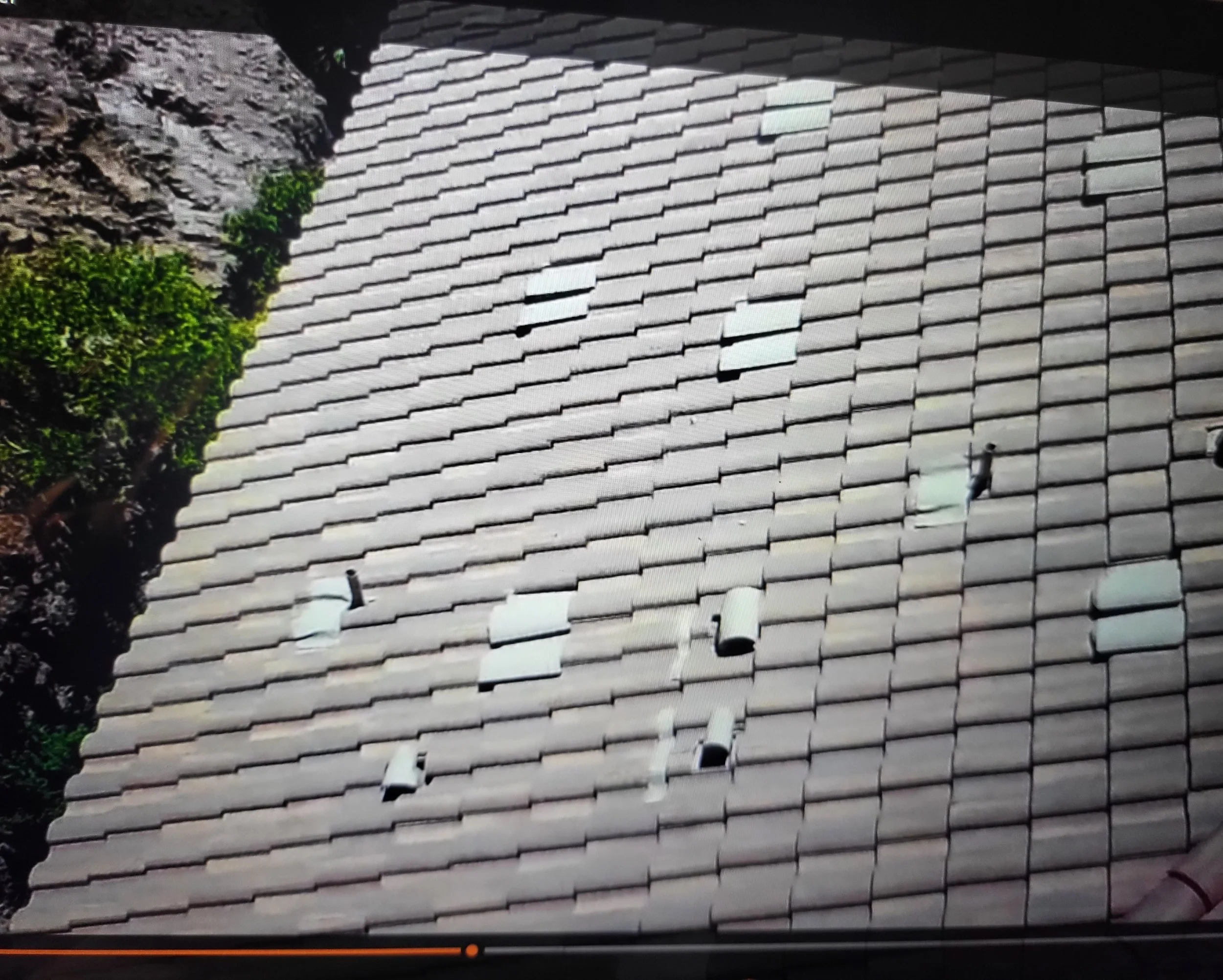View of a tiled roof with several vent pipes protruding from the surface.
