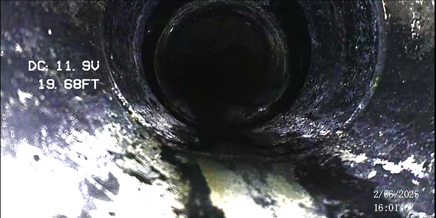 The image shows the interior of a pipe with a dark, possibly wet, surface. On the left side, there are labels indicating electrical measurements: 'DC 11.9V' and '19.68FT.' In the bottom right corner, there is a date and time stamp: '2/06/2025 16:01:0