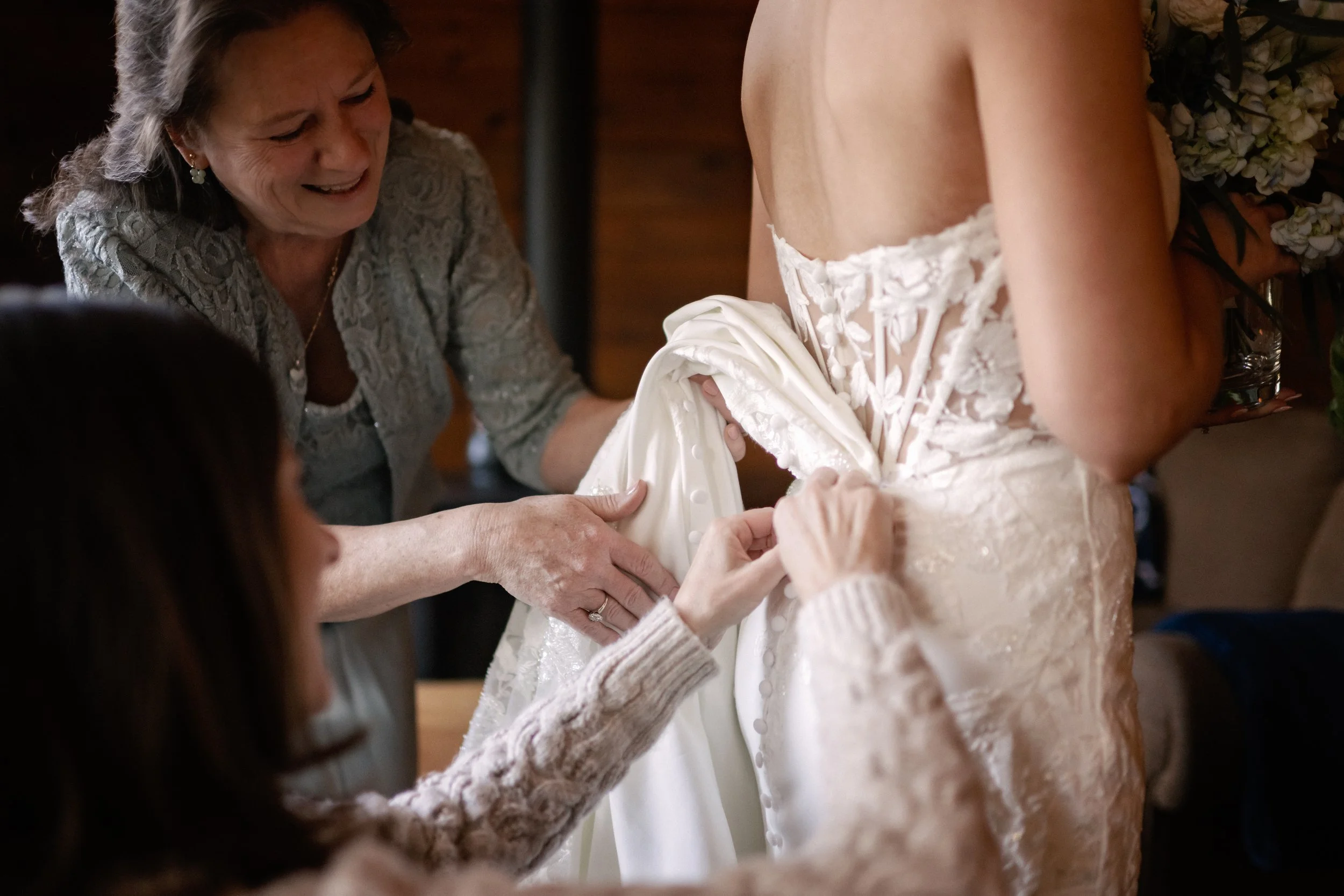 Mother of Bride and friend helping Bride with her dress in Yosemite