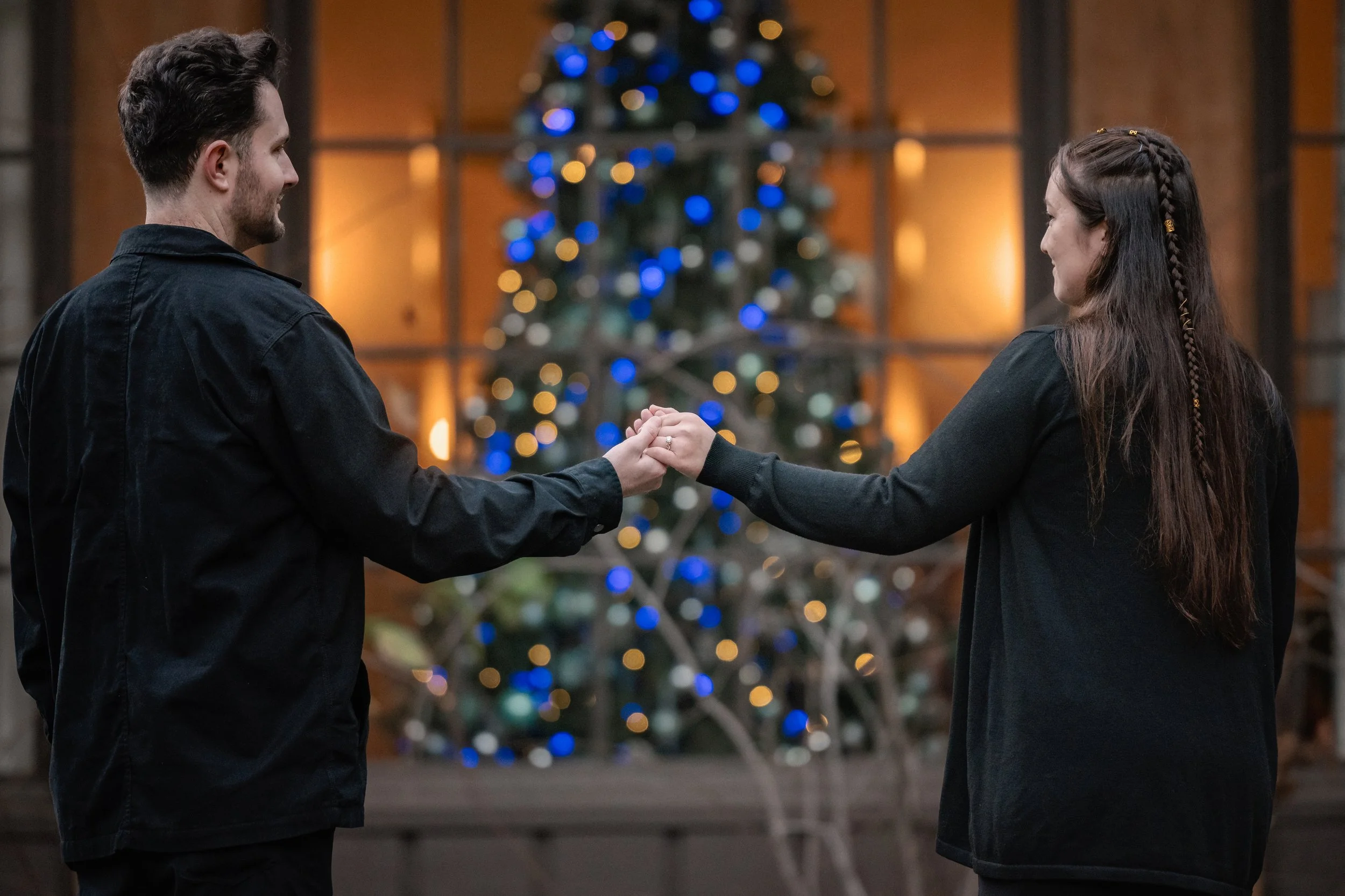 Couple holding hands in front of the Christmas tree at Ahwahnee Hotel in Yosemite National Park