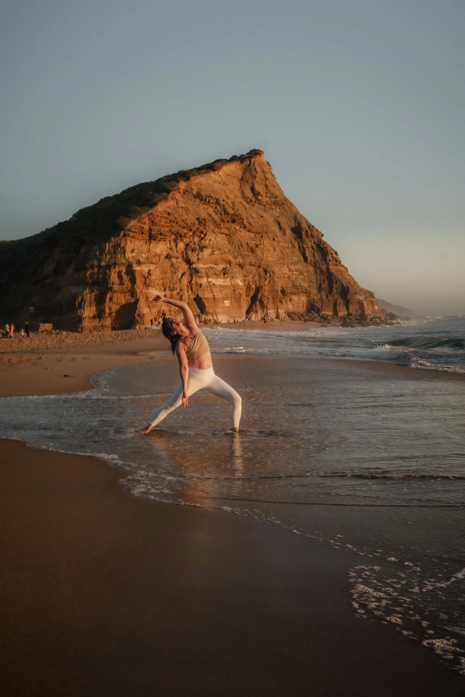 Yoga auf einer Felsformation am Meer in Portugal