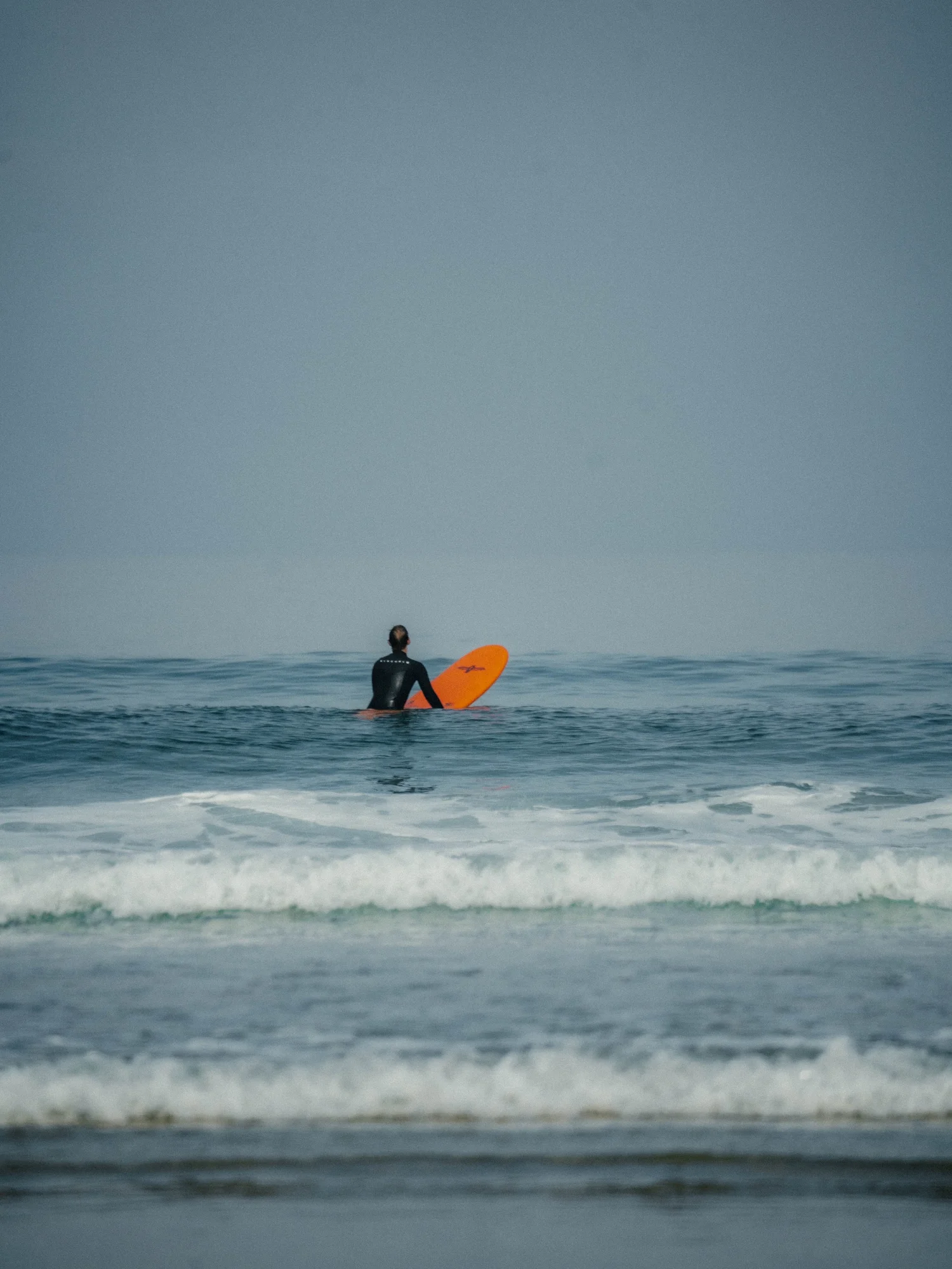 Surfer im Nebel, minimalistische Küstenaufnahme in Cornwall