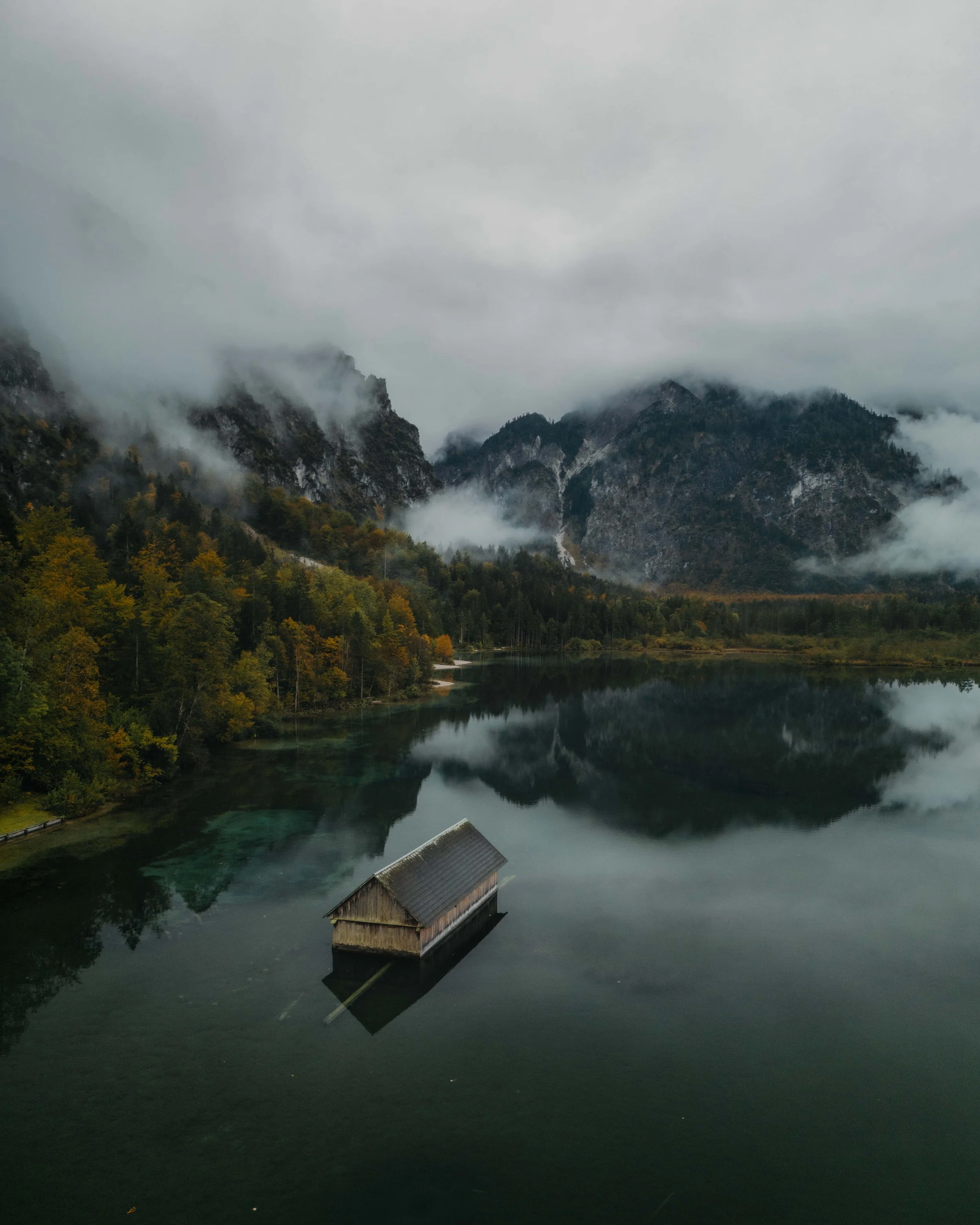 Nebliger Almsee in einer ruhigen Berglandschaft in Österreich