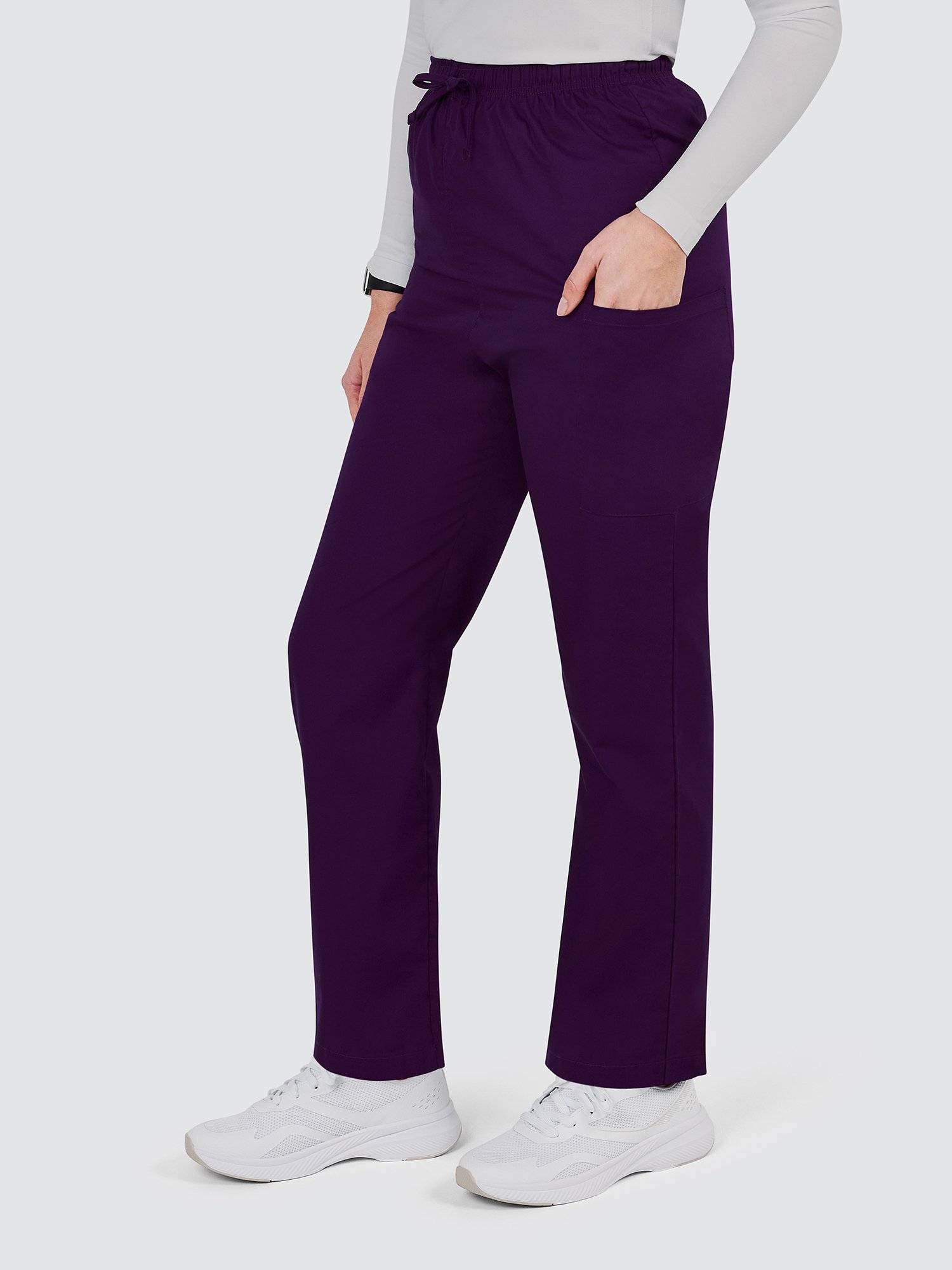 A person wearing a gray long-sleeve shirt and dark purple pants with an elastic waistband and pockets. They have white sneakers and are standing against a plain light background.