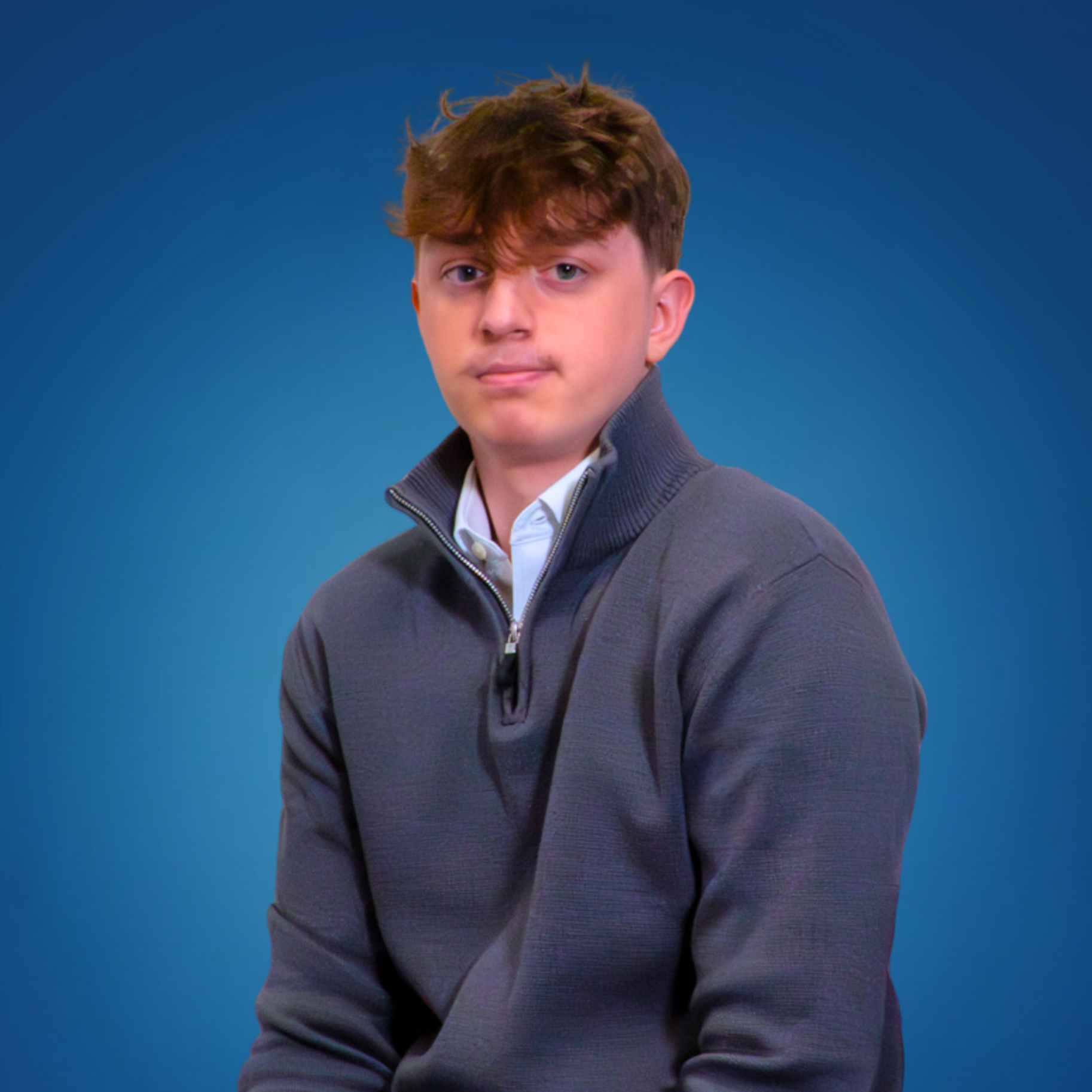 Portrait of a team member wearing a grey quarter-zip top.
