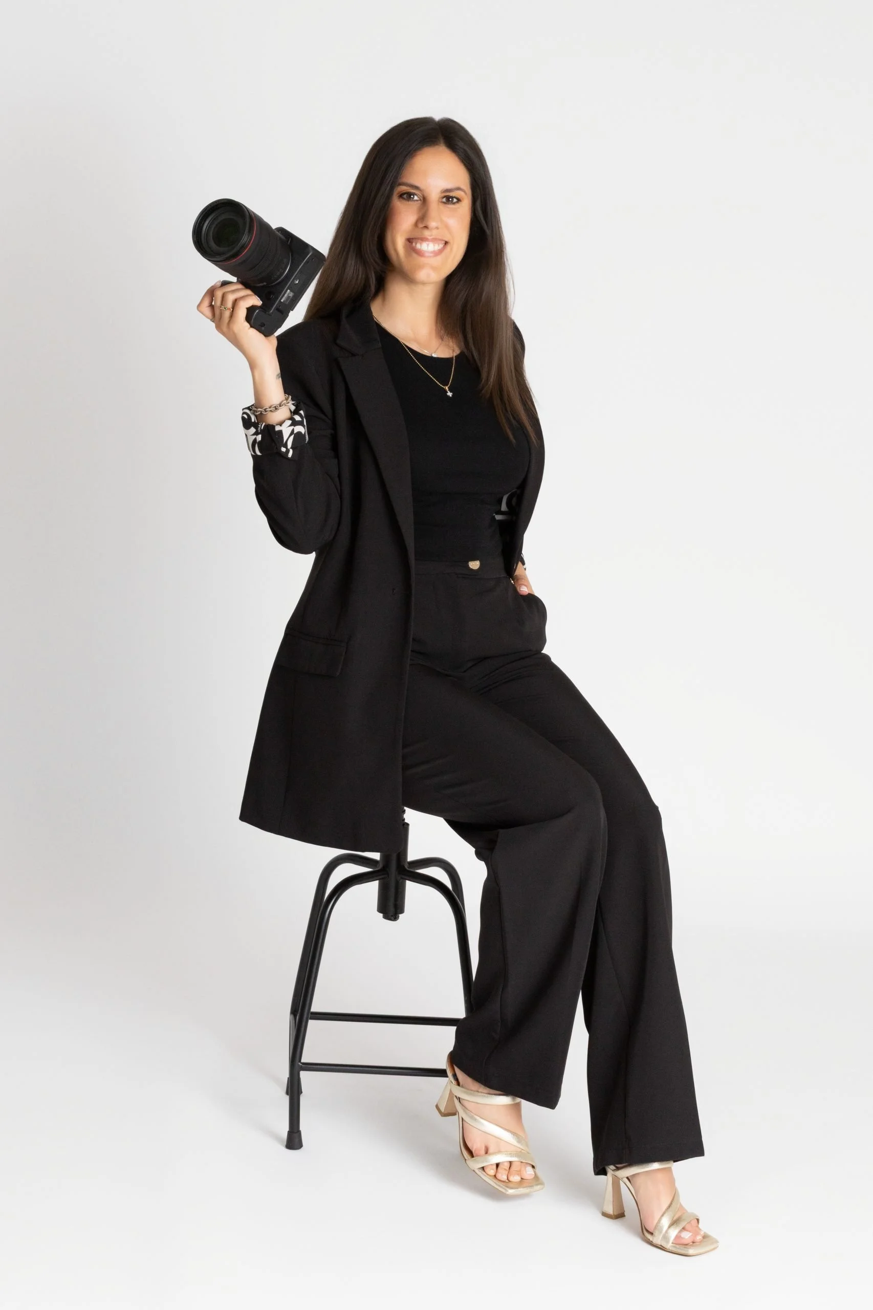 Una pareja paseando por un jardín decorado para una boda, con sillas blancas y arreglos florales, en un día nublado.