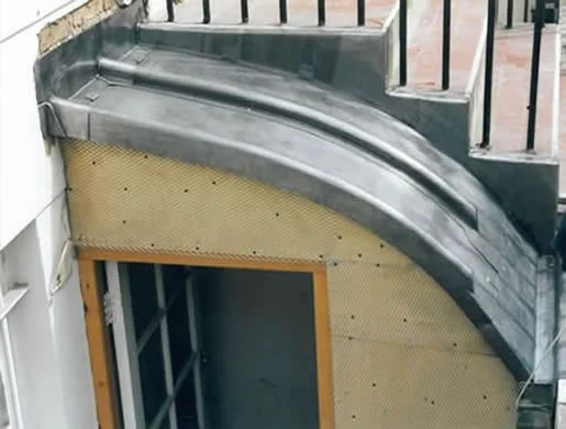 Close-up of a modern metal spiral staircase railing and underside of the staircase.