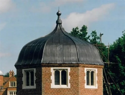 Brick building with a rounded, domed black roof and decorative windows
