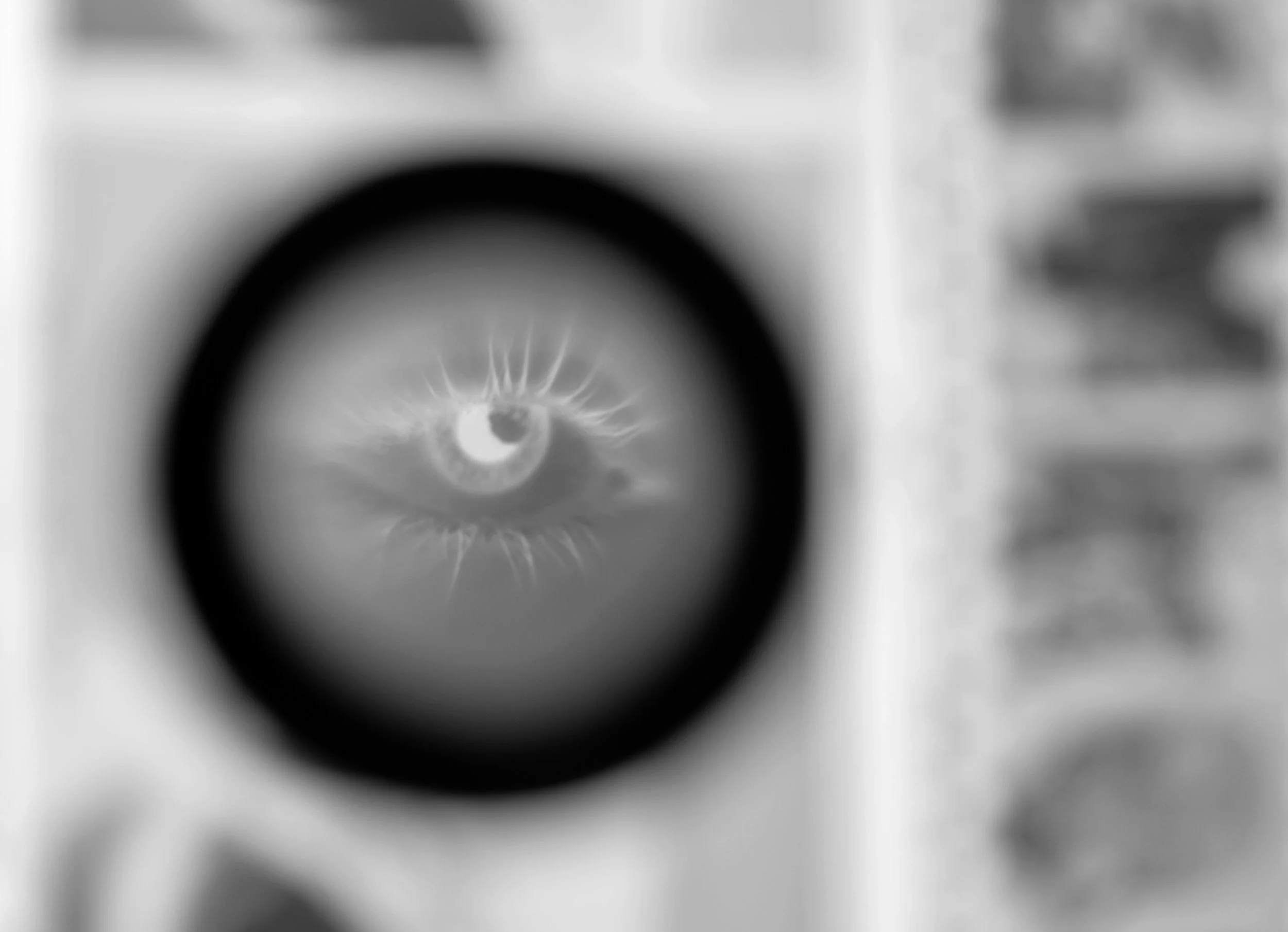 Black and white image showing a close-up of a bathroom scale with an eye reflected in the center