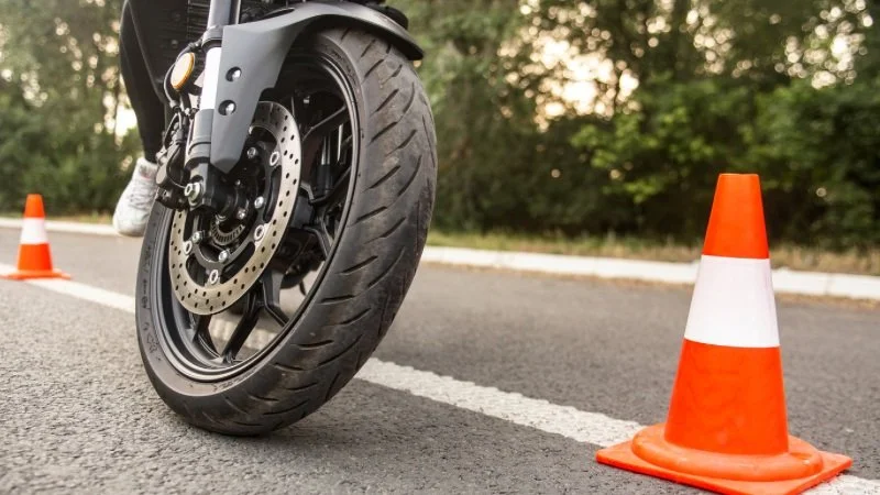 Motorrad auf der Straße, umgeben von Verkehrsleitkegeln.