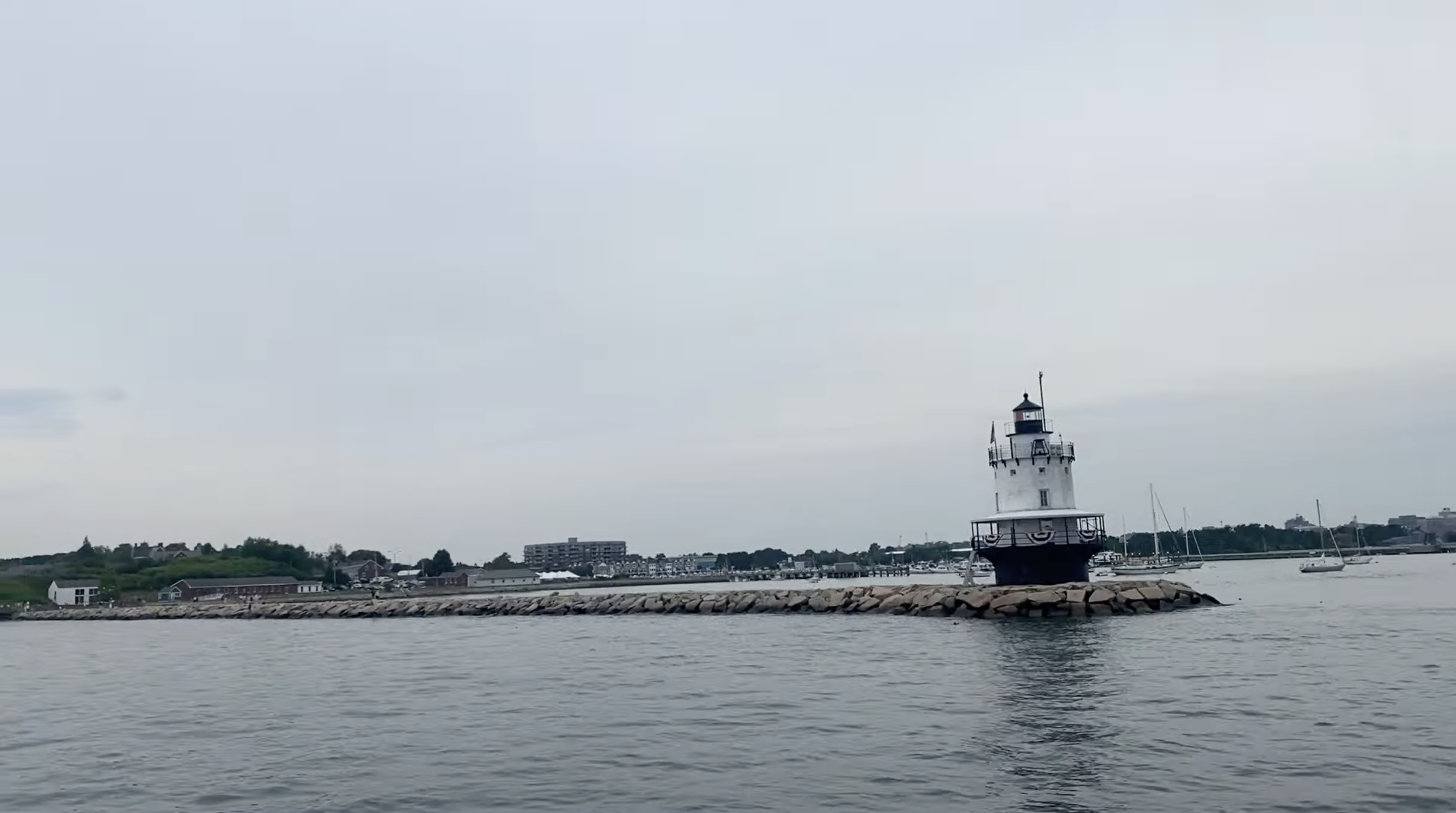 A lighthouse on the edge of the coast along the water