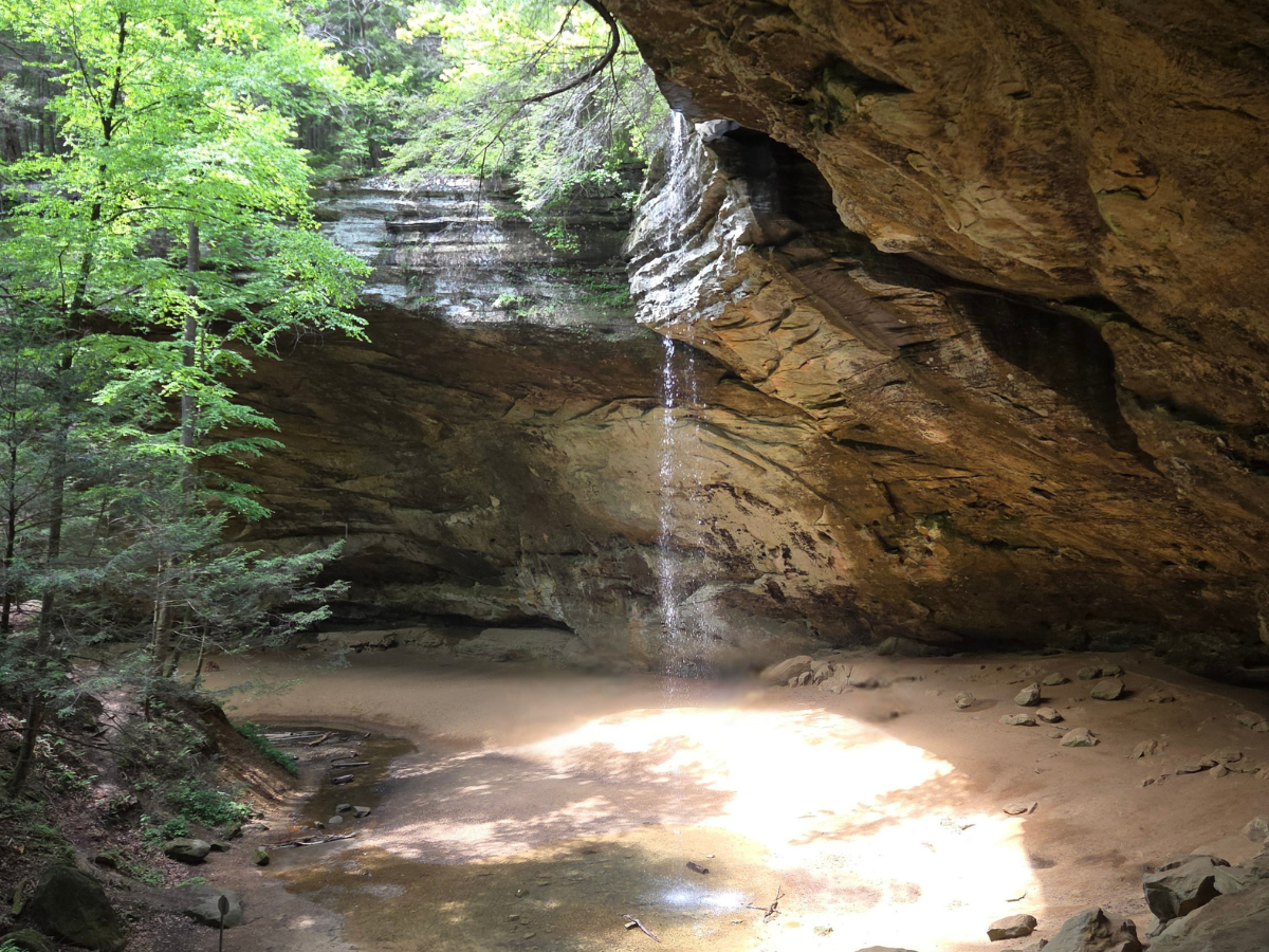 A waterfall with trees off to the lefthand side of the waterfall