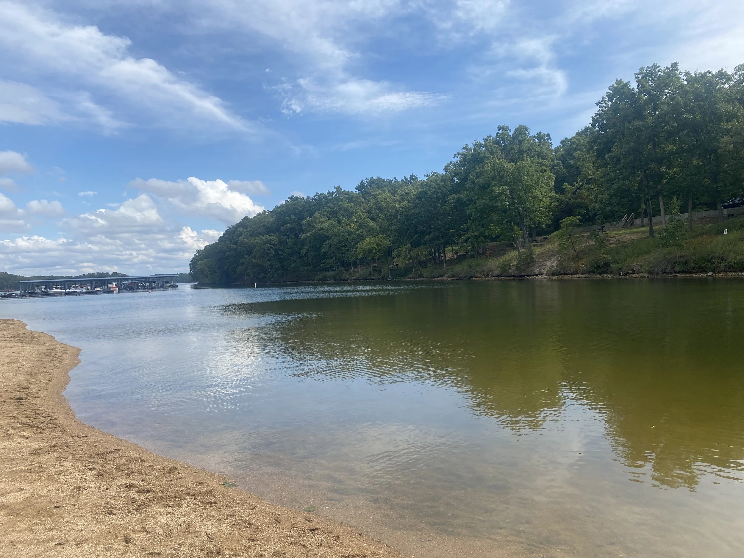 A lake with beach sand where the water meets the sand.