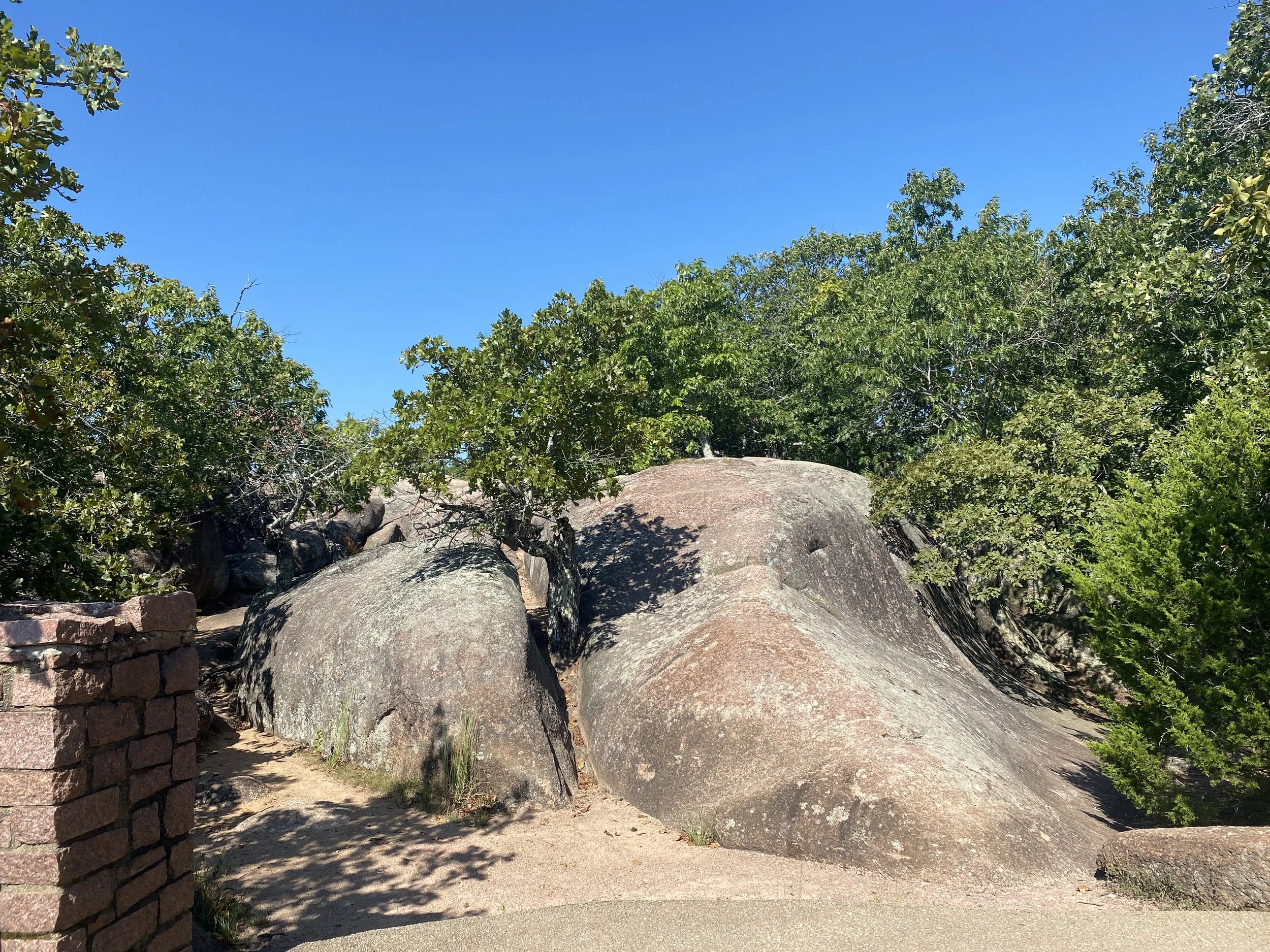 Two large rock formations with a walking path through the middle of them.