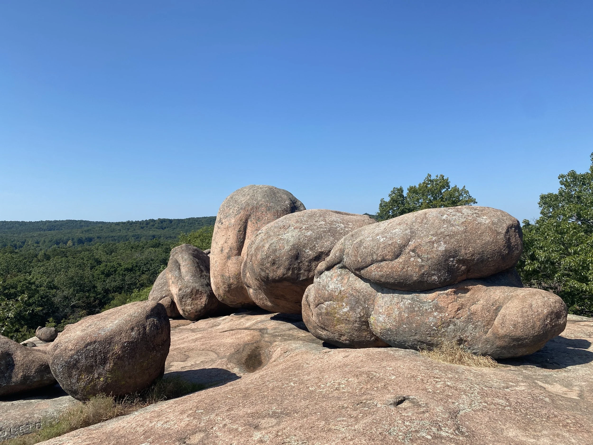 Several rocks stacked on top of each other with a forest in the background.