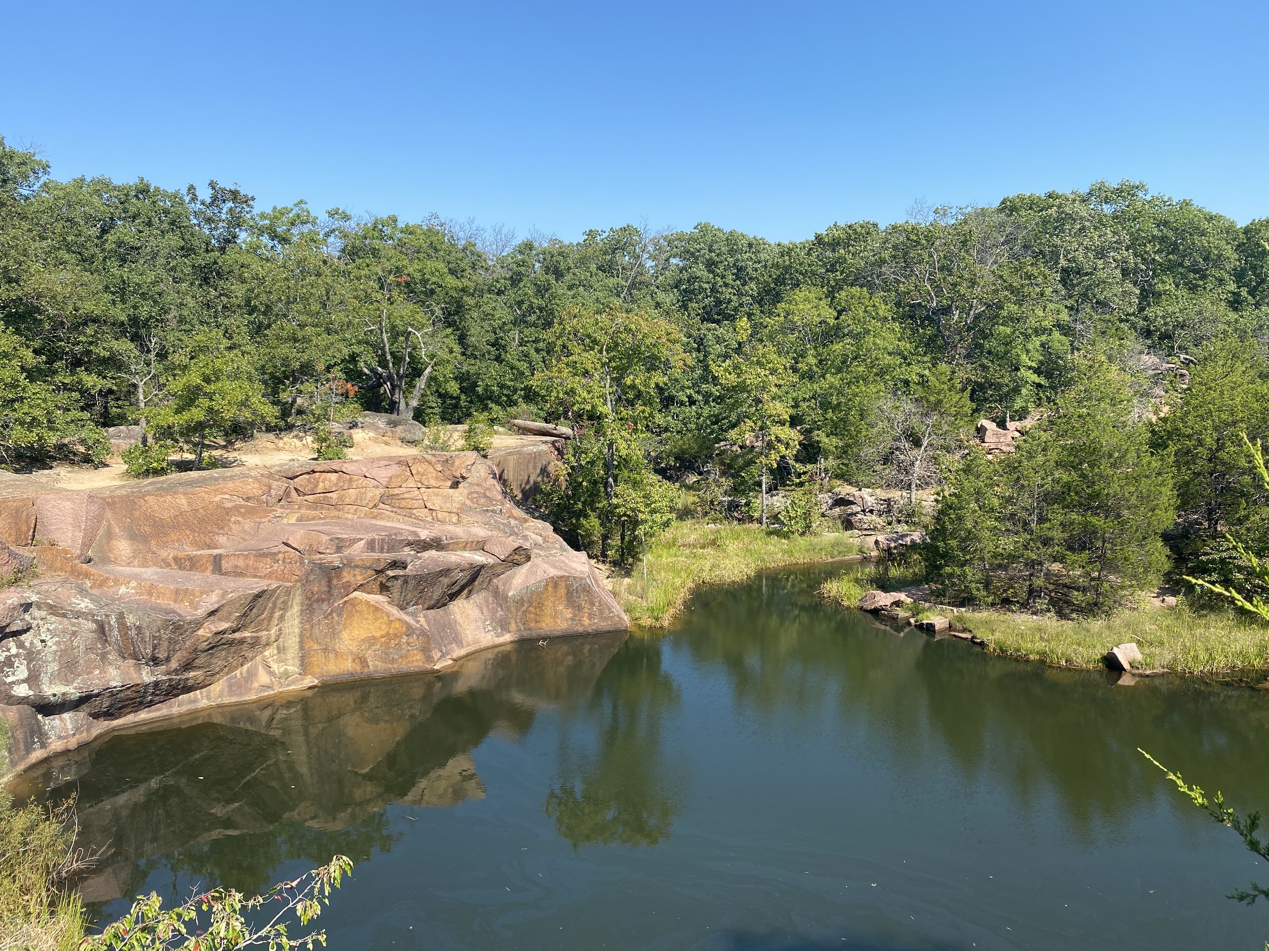 A clear body of water with rocks surrounding the leftside of the waterbody.