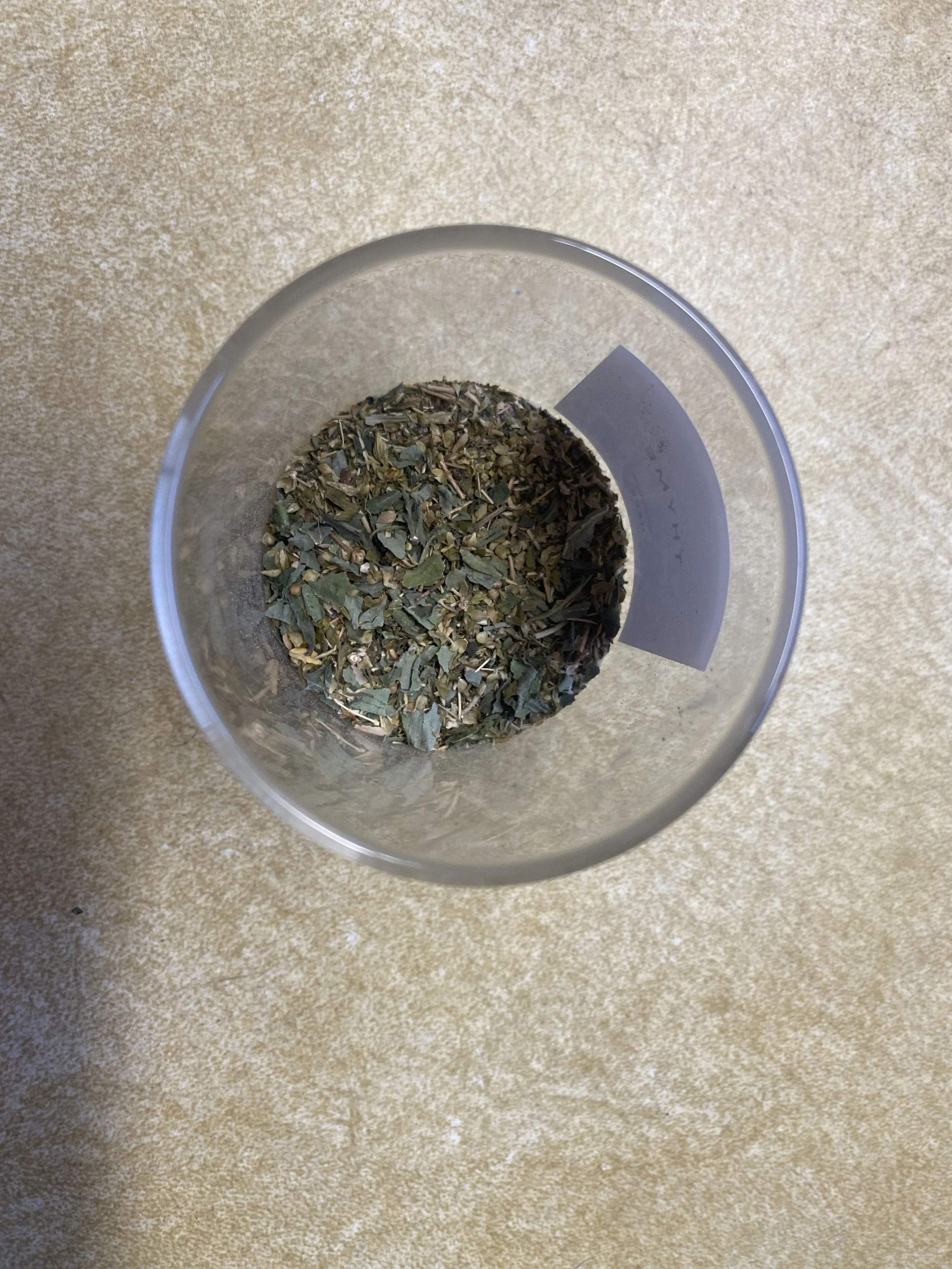 Glass jar with greek seasoning blend.