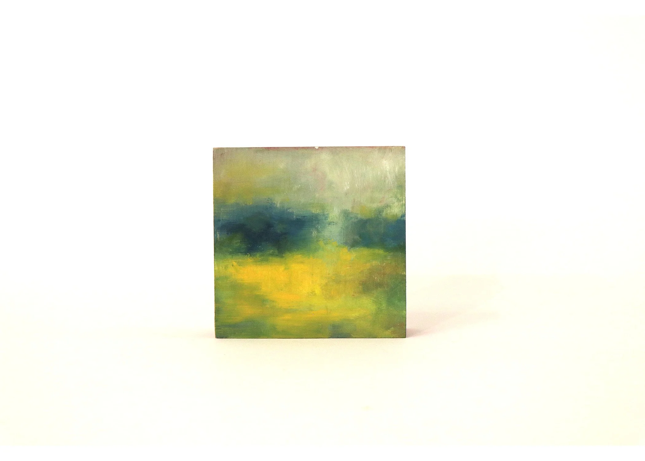 Small abstract landscape painting with green, yellow, and blue hues, displayed on a white background.