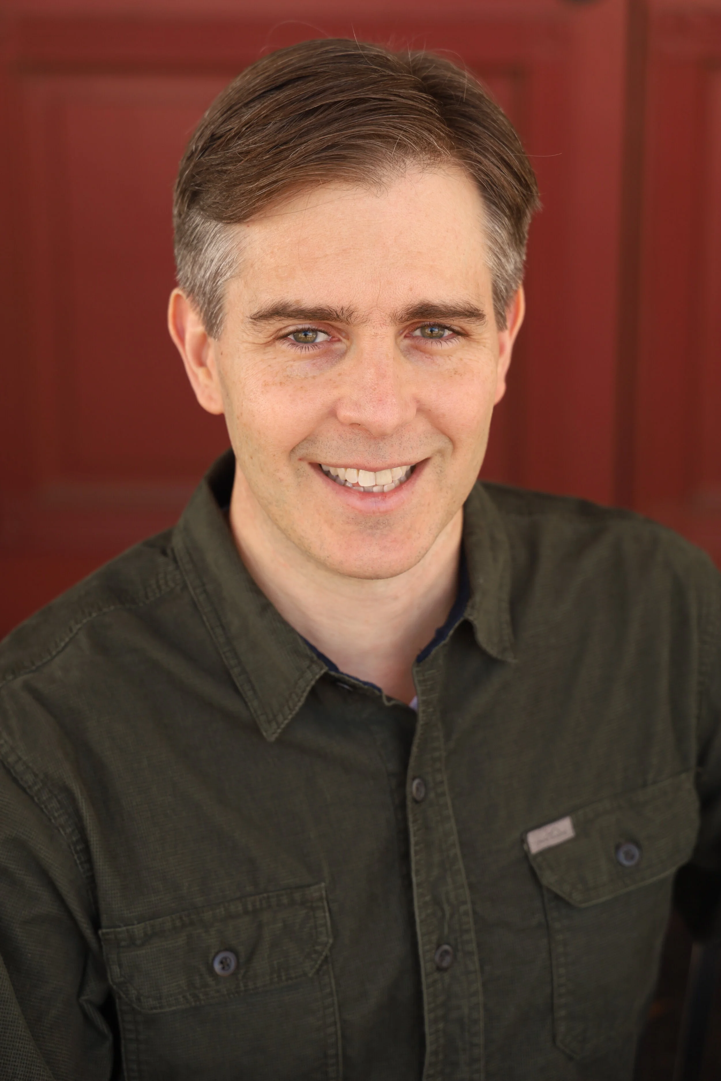Headshot of Sean Hale smiling with a red background